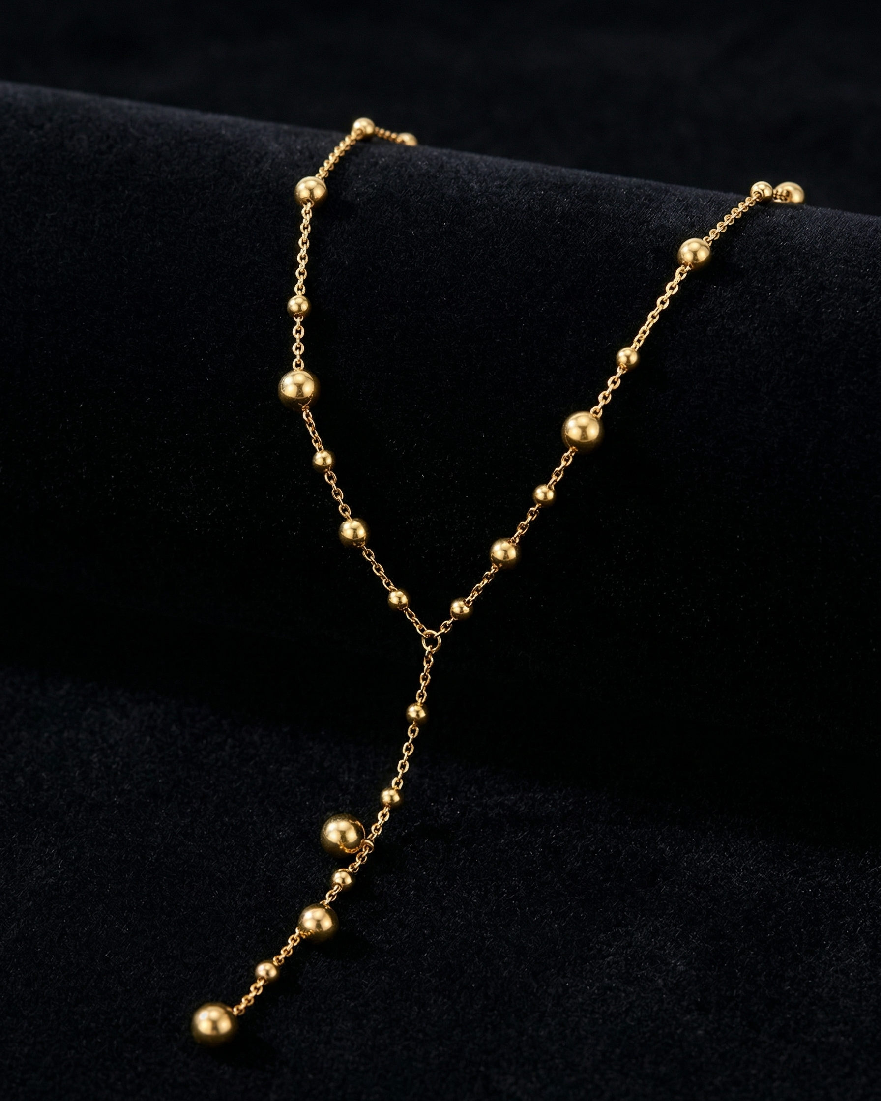 Gold necklace with beads on a black background