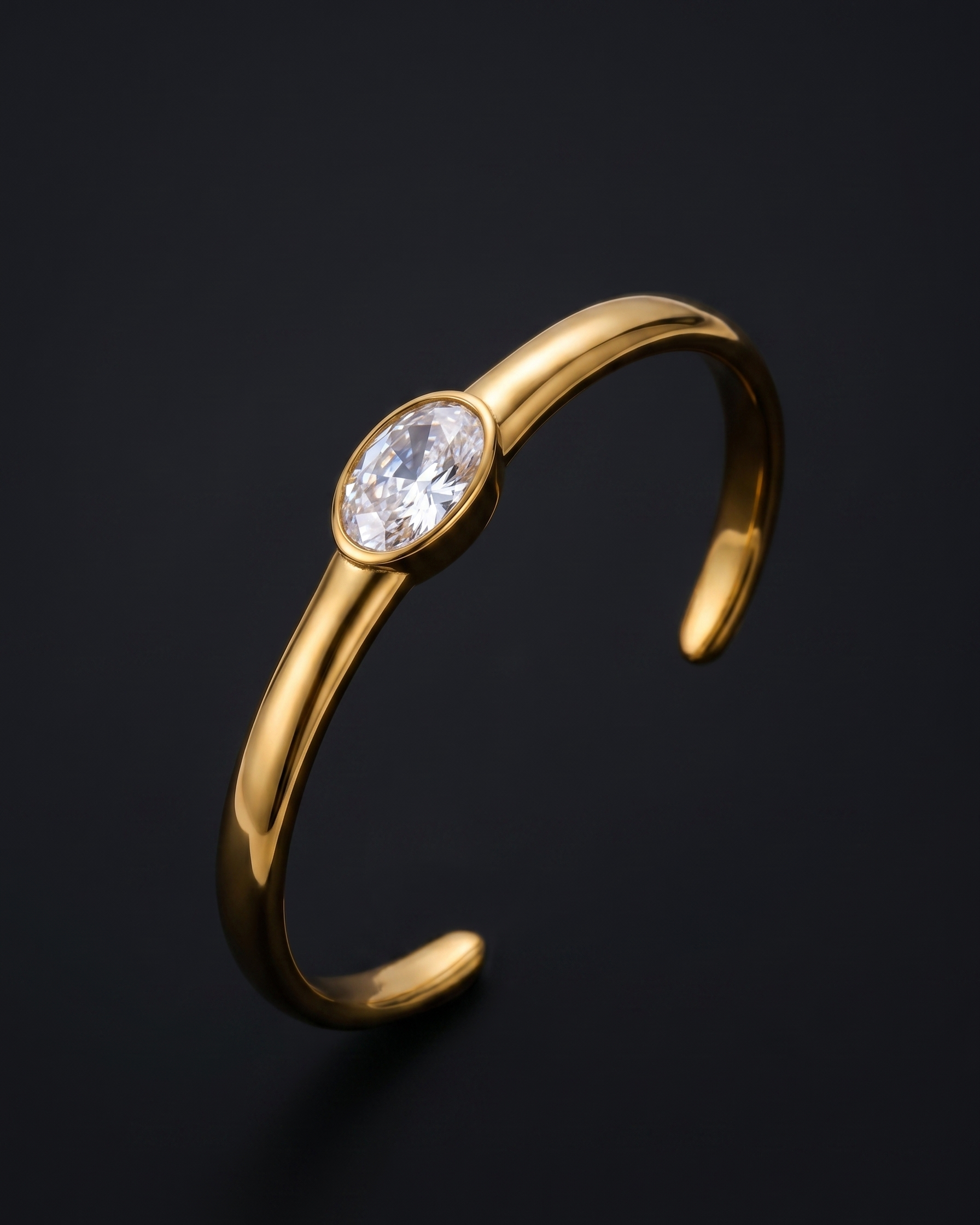 Gold bracelet with a central gemstone on a dark background