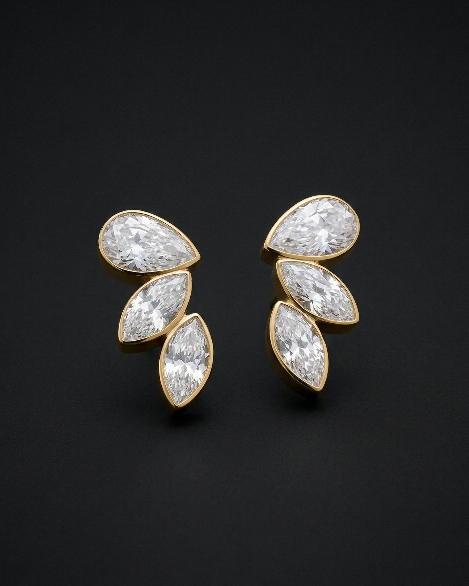 Pair of gold and diamond earrings on a black background
