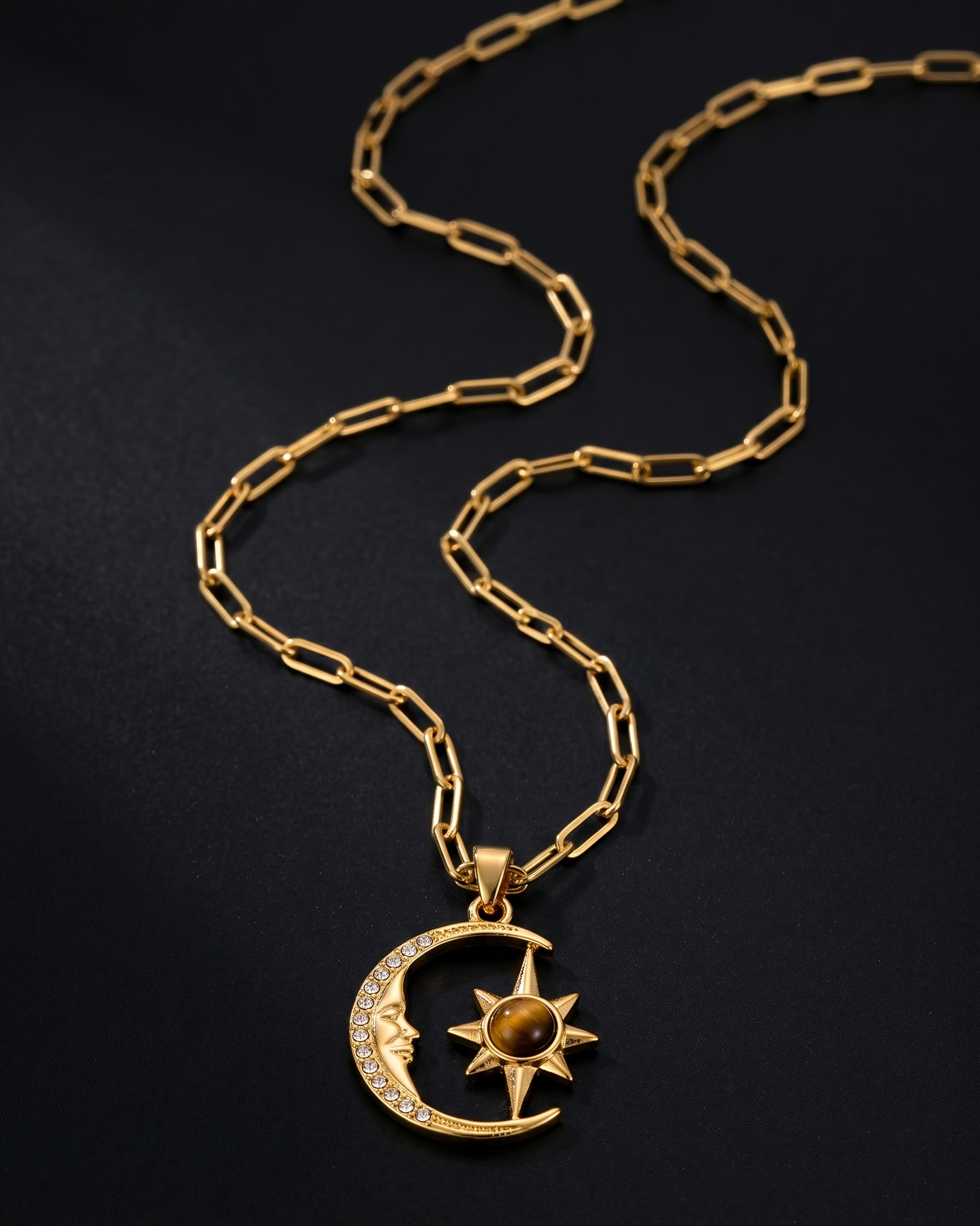 Gold necklace with a moon and star pendant on a black background