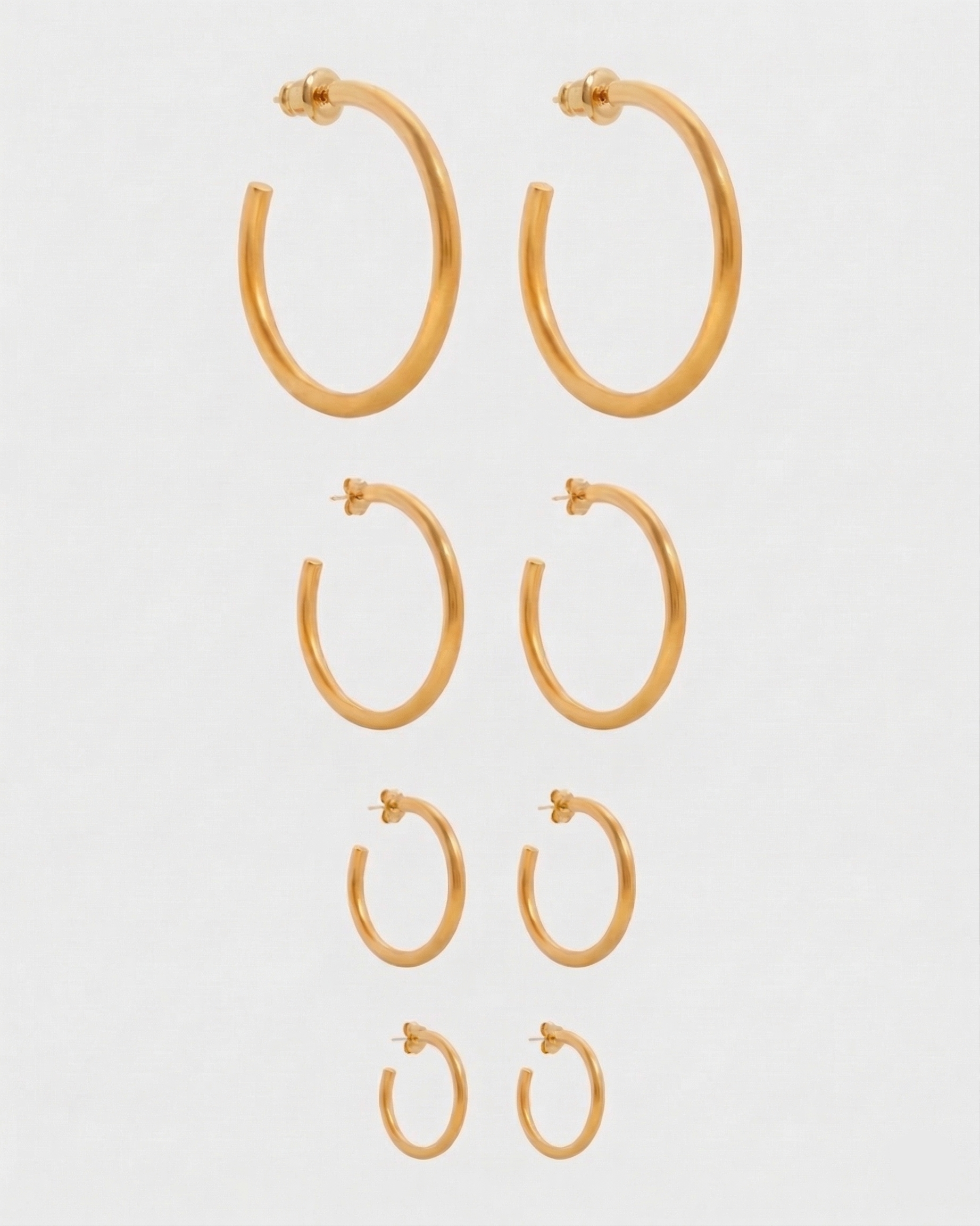 Set of gold hoop earrings on a white background