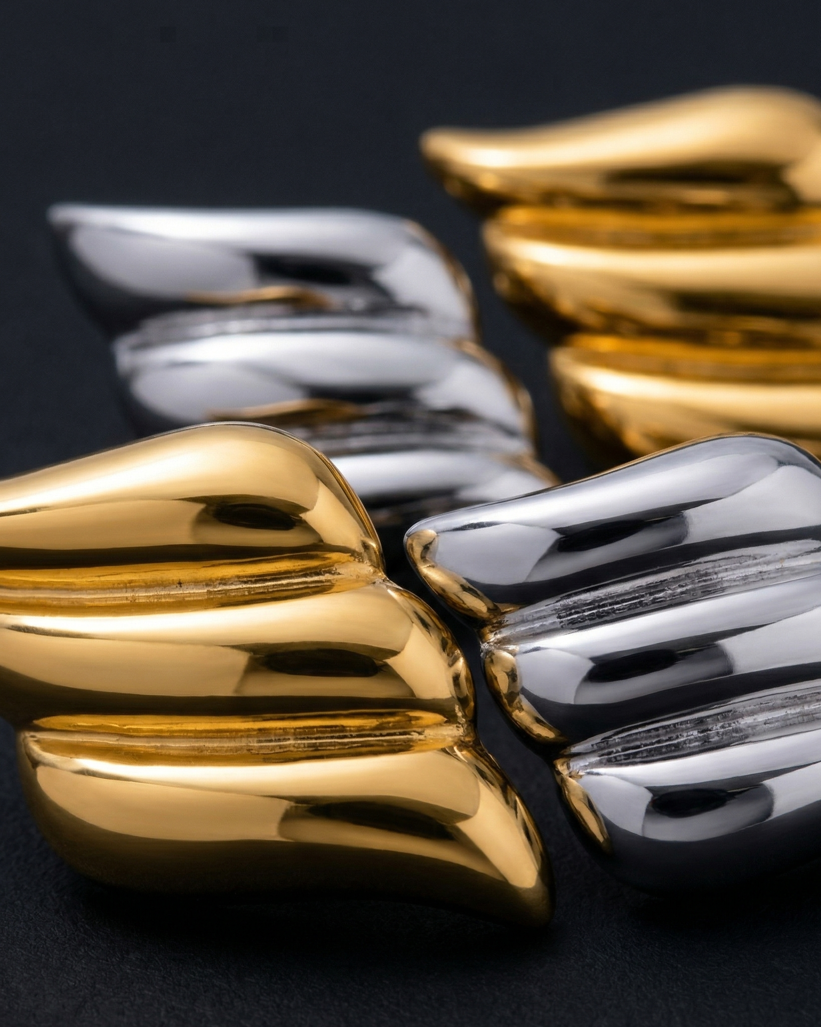 Gold and silver cufflinks on a black background