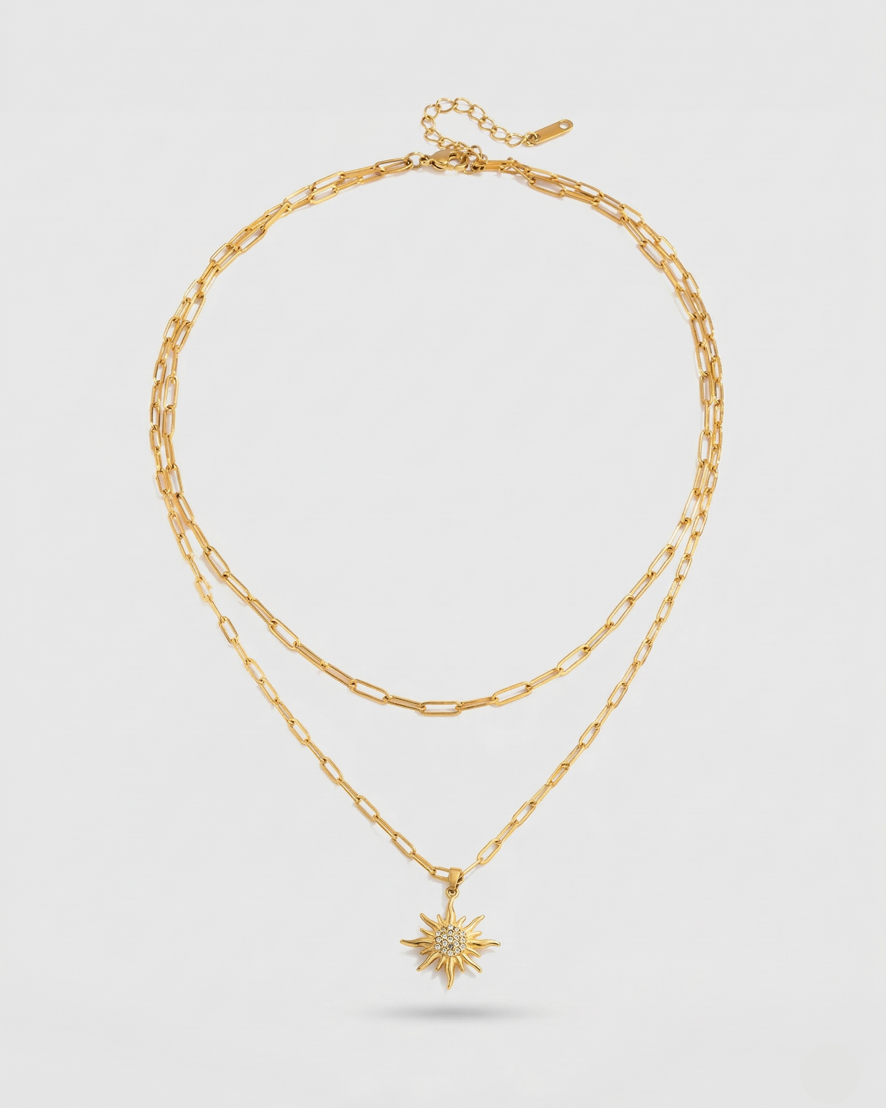 Gold necklace with a star pendant on a light gray background