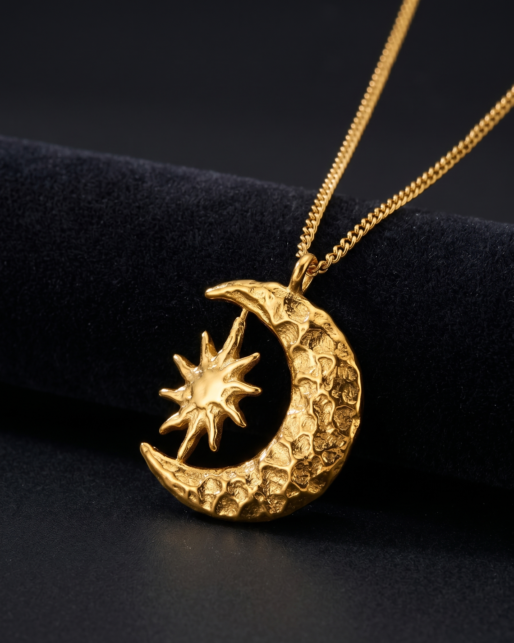 Gold necklace with a moon and star pendant on a black background