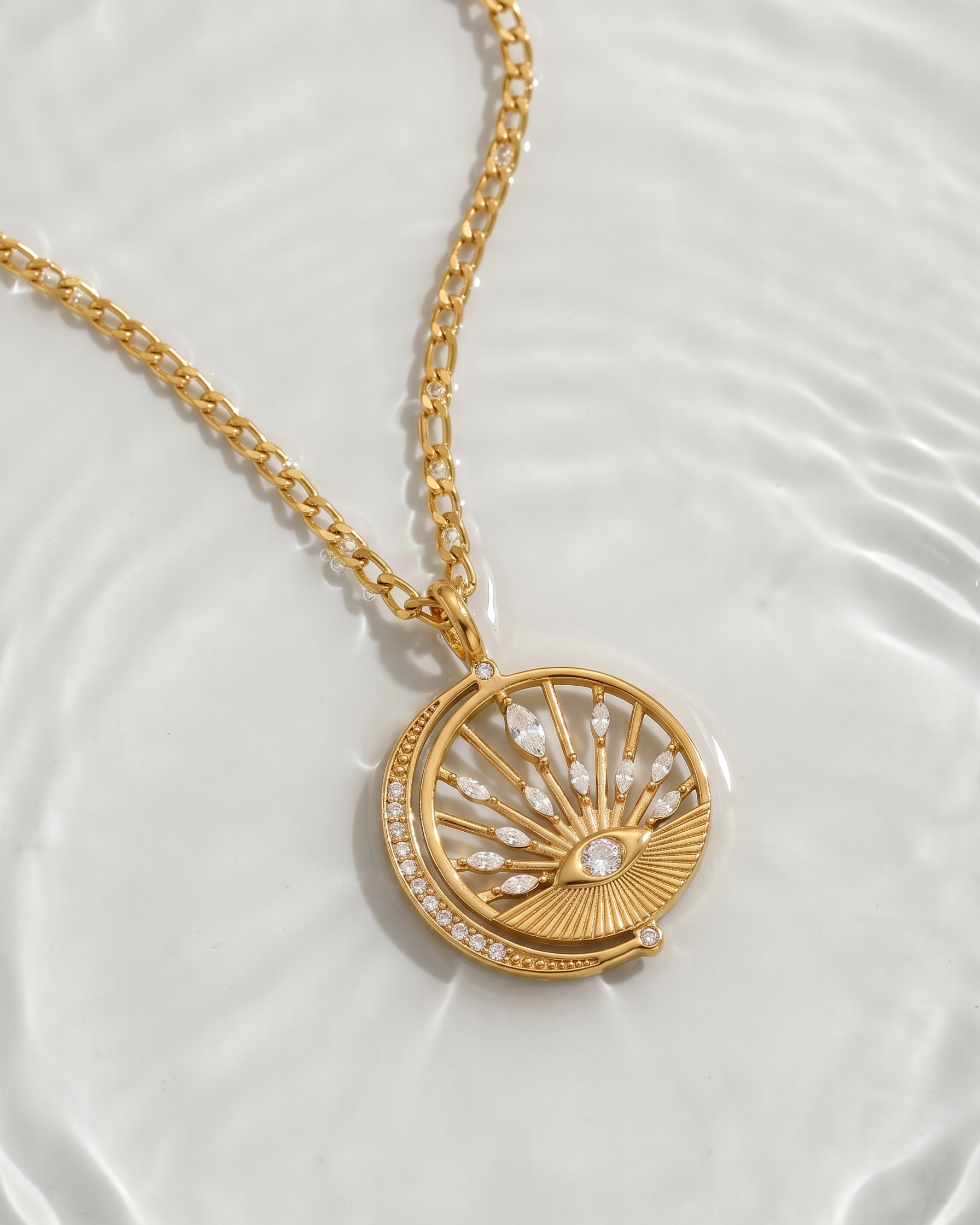 Gold necklace with a decorative pendant on a white background