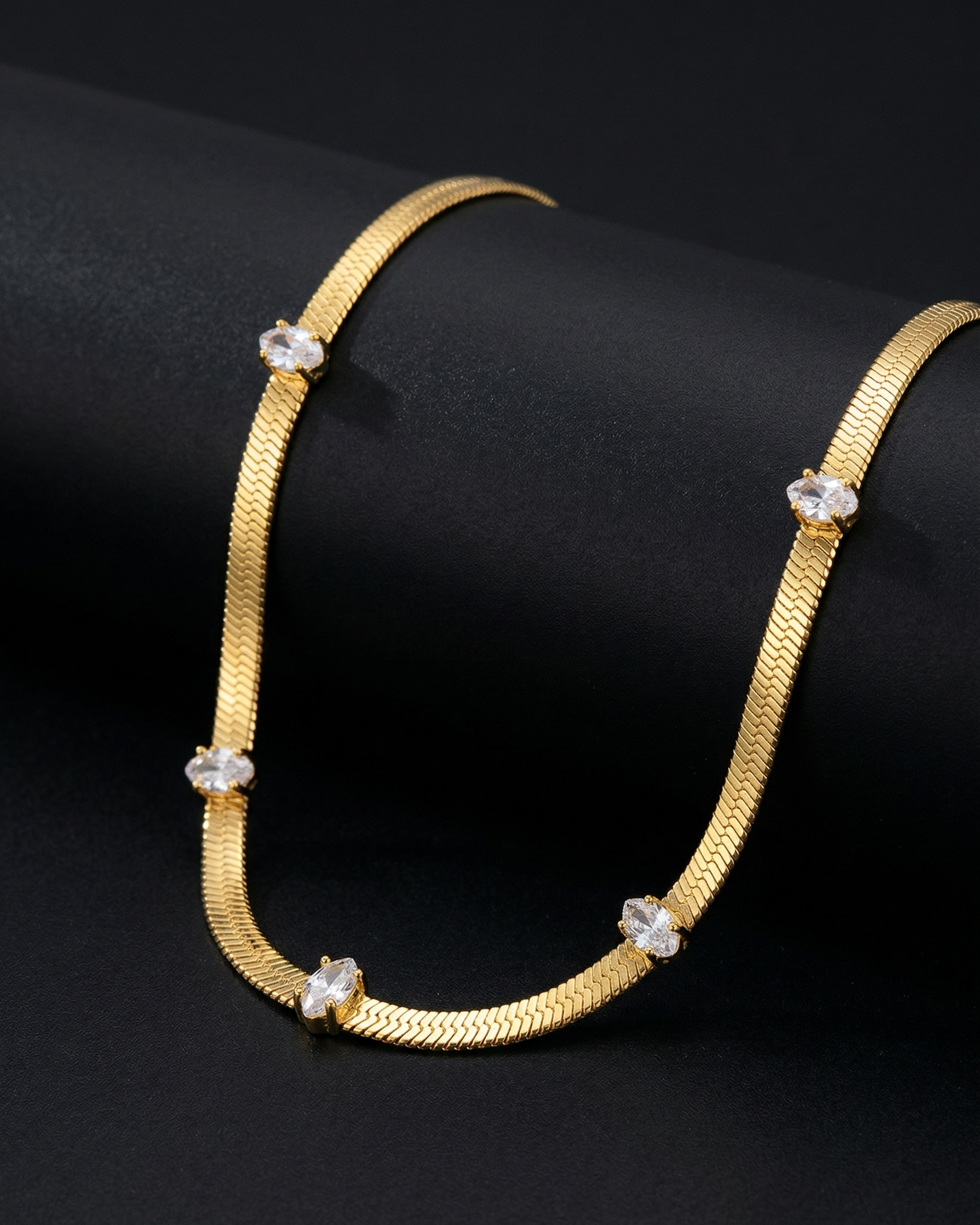 Gold necklace with diamond-like beads on a black background