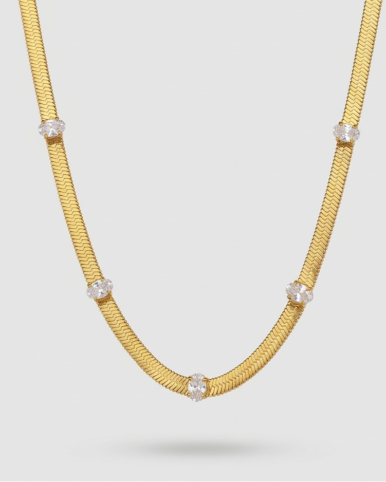 Gold necklace with embedded diamonds on a light gray background