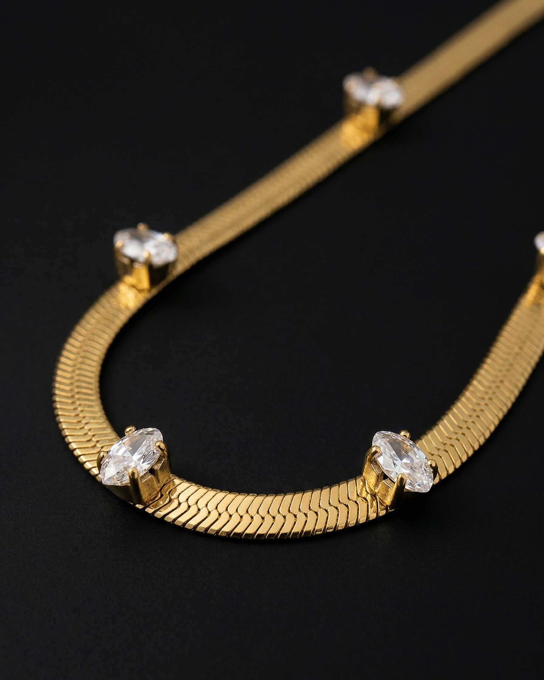 Gold necklace with diamond-like stones on a black background
