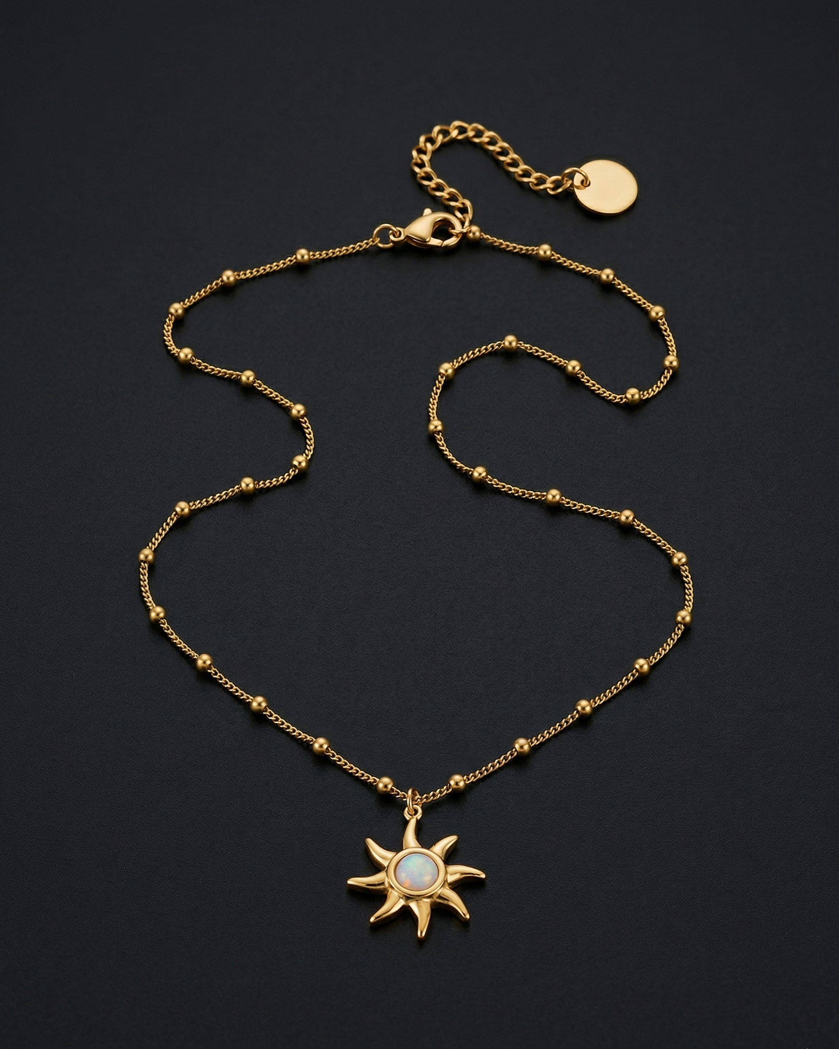 Gold necklace with a sun pendant on a dark background