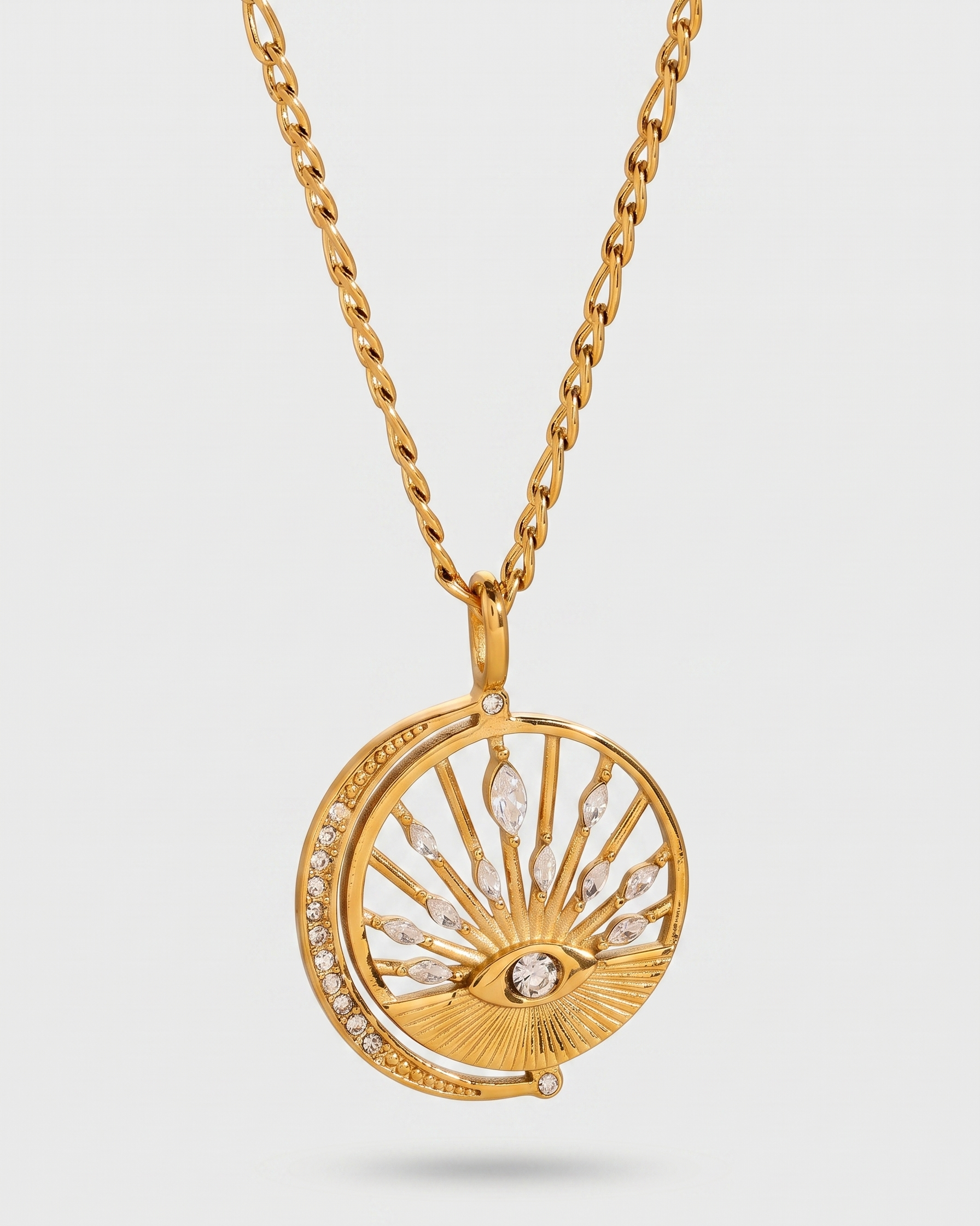 Gold necklace with a circular pendant on a light gray background