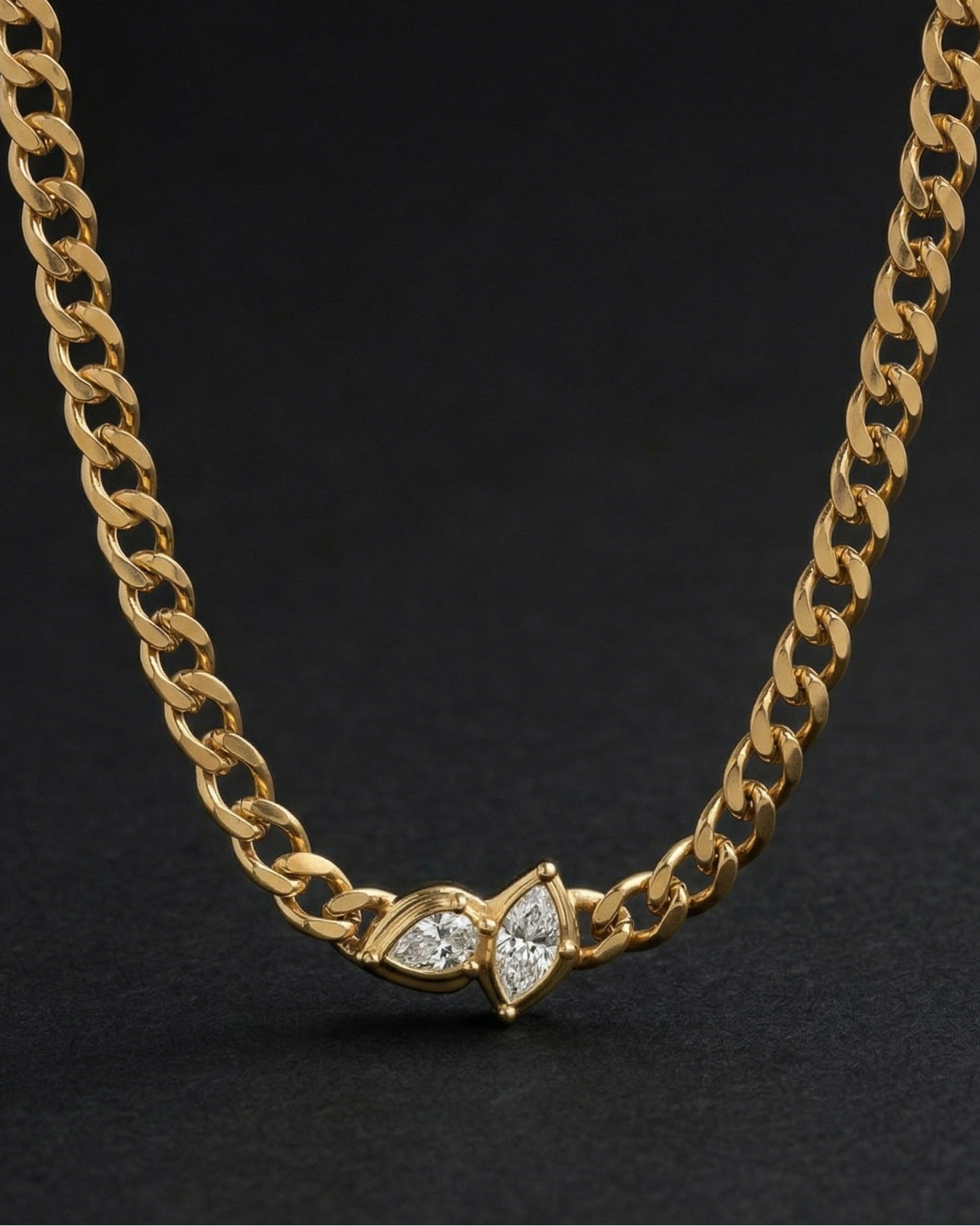 Gold chain necklace with a diamond pendant on a black background