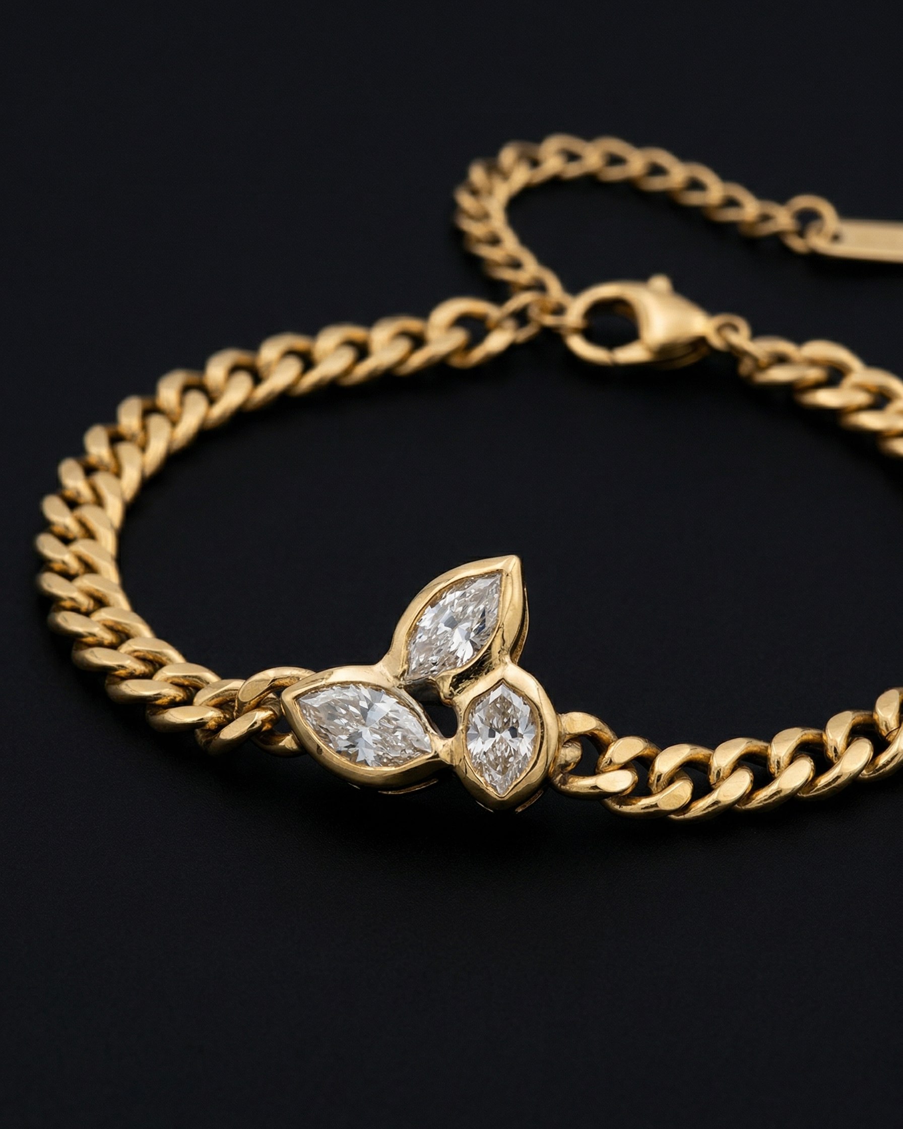 Gold bracelet with diamond leaf design on a black background