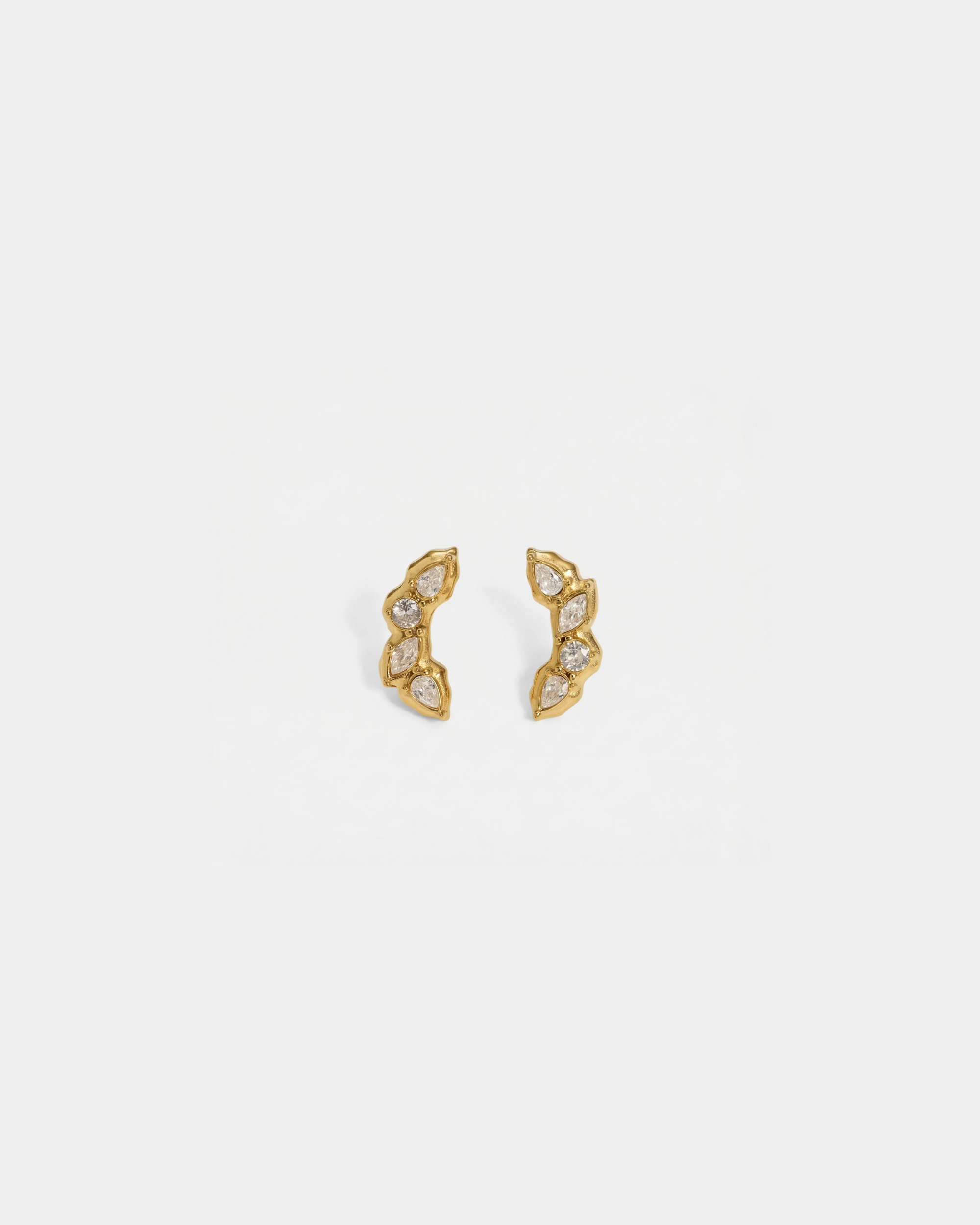Gold earrings with small diamonds on a light gray background