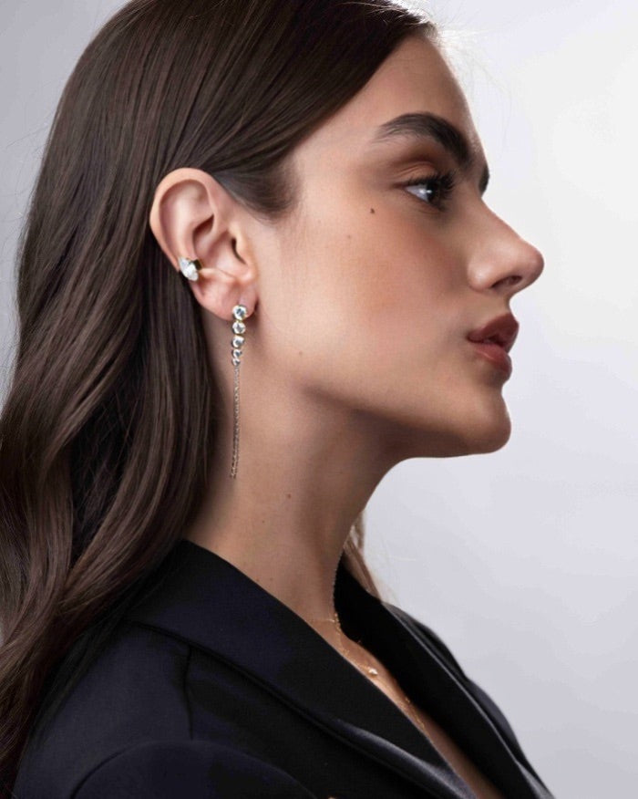 Close-up of a woman wearing earrings with a plain background