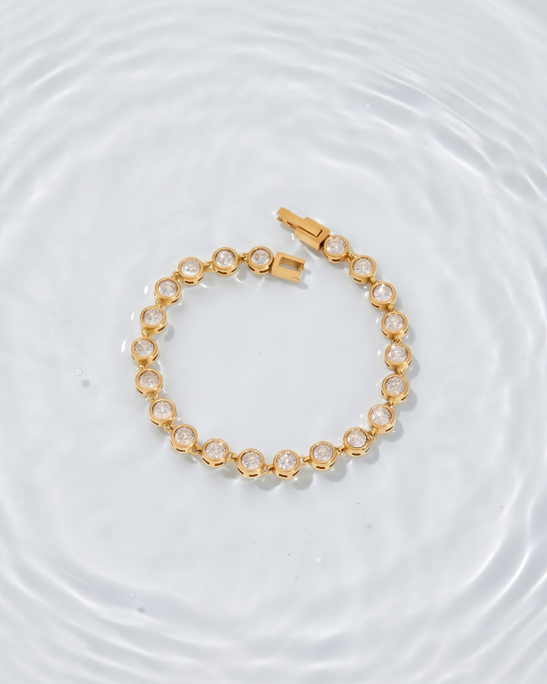 Gold bracelet with clear stones on a white background