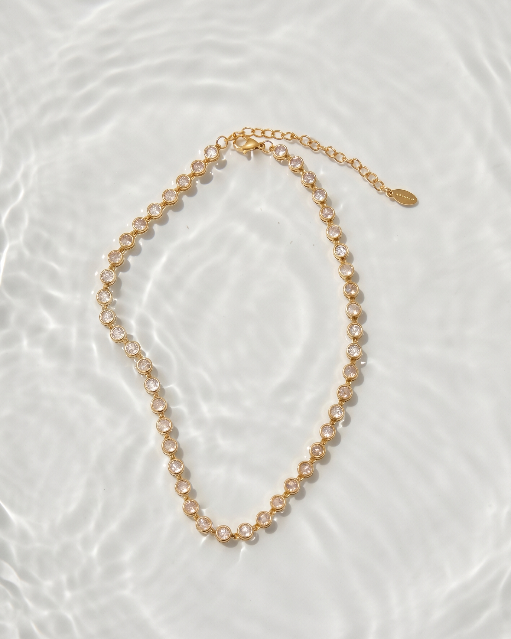 Gold chain necklace on a textured white surface