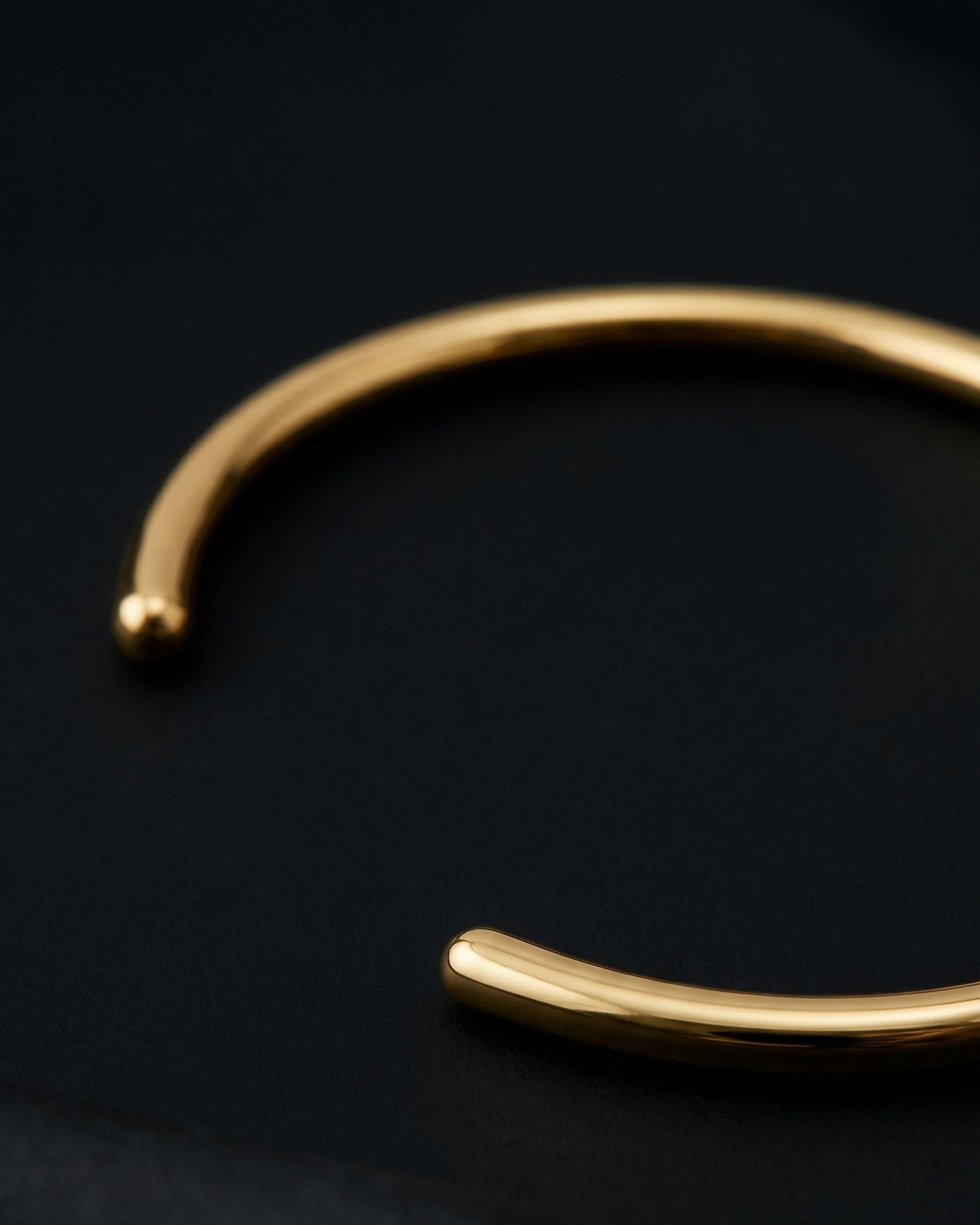 Gold bracelet on a dark background
