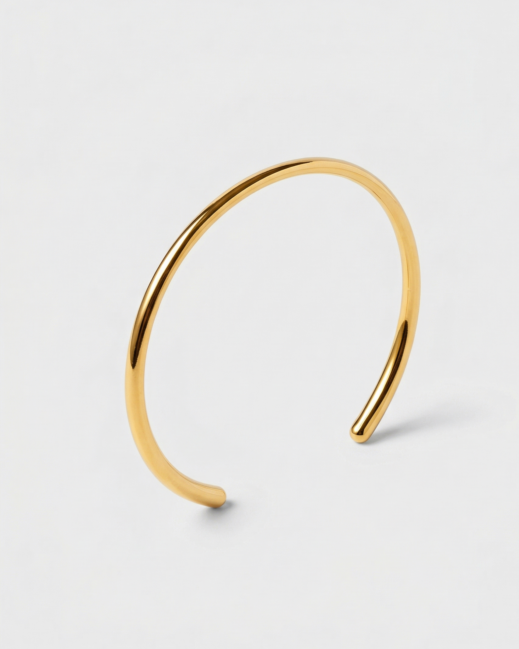 Gold hoop earring on a light gray background