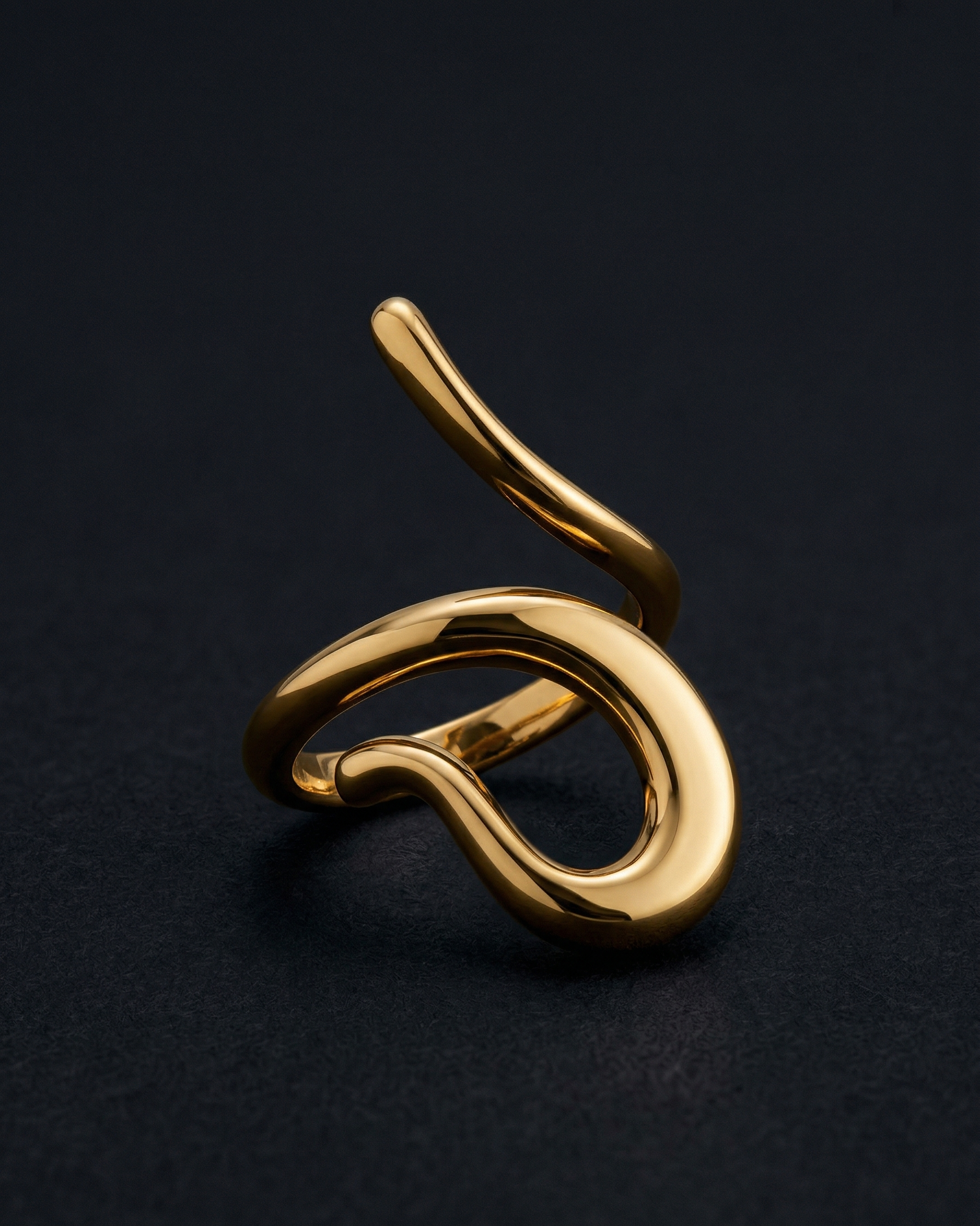 Gold ring with a unique design on a black background