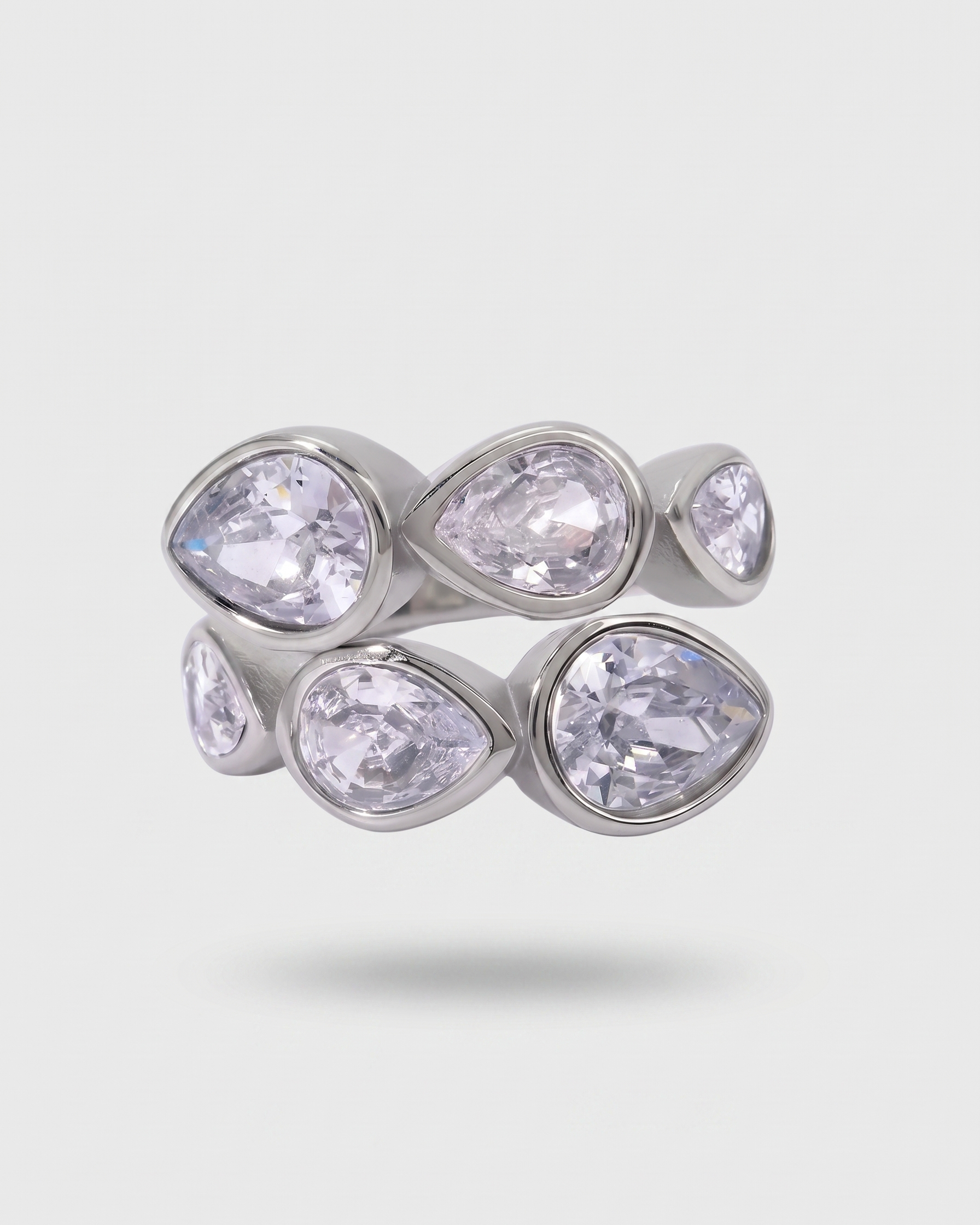 Silver ring with clear gemstones on a light gray background