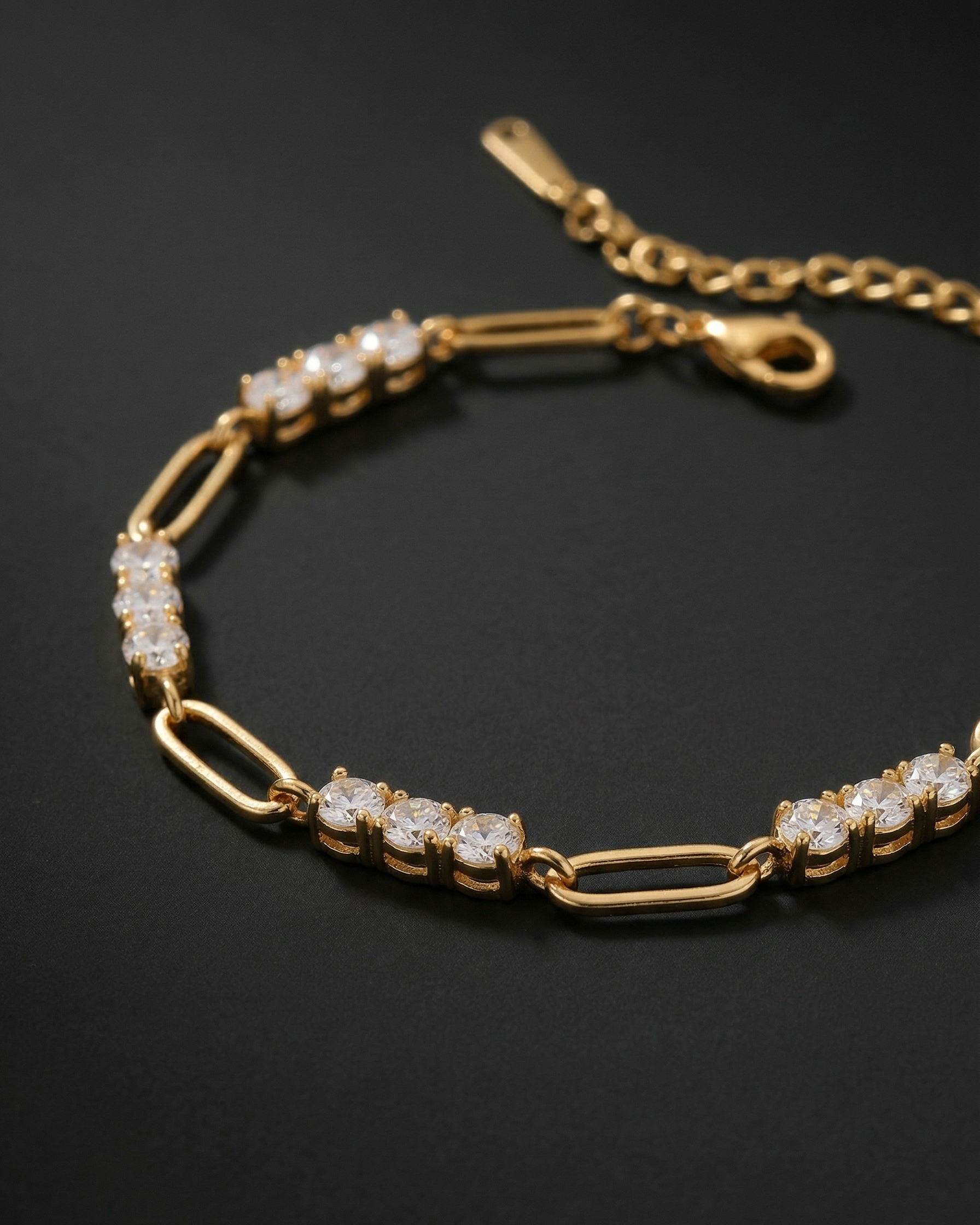 Gold bracelet with diamond accents on a black background