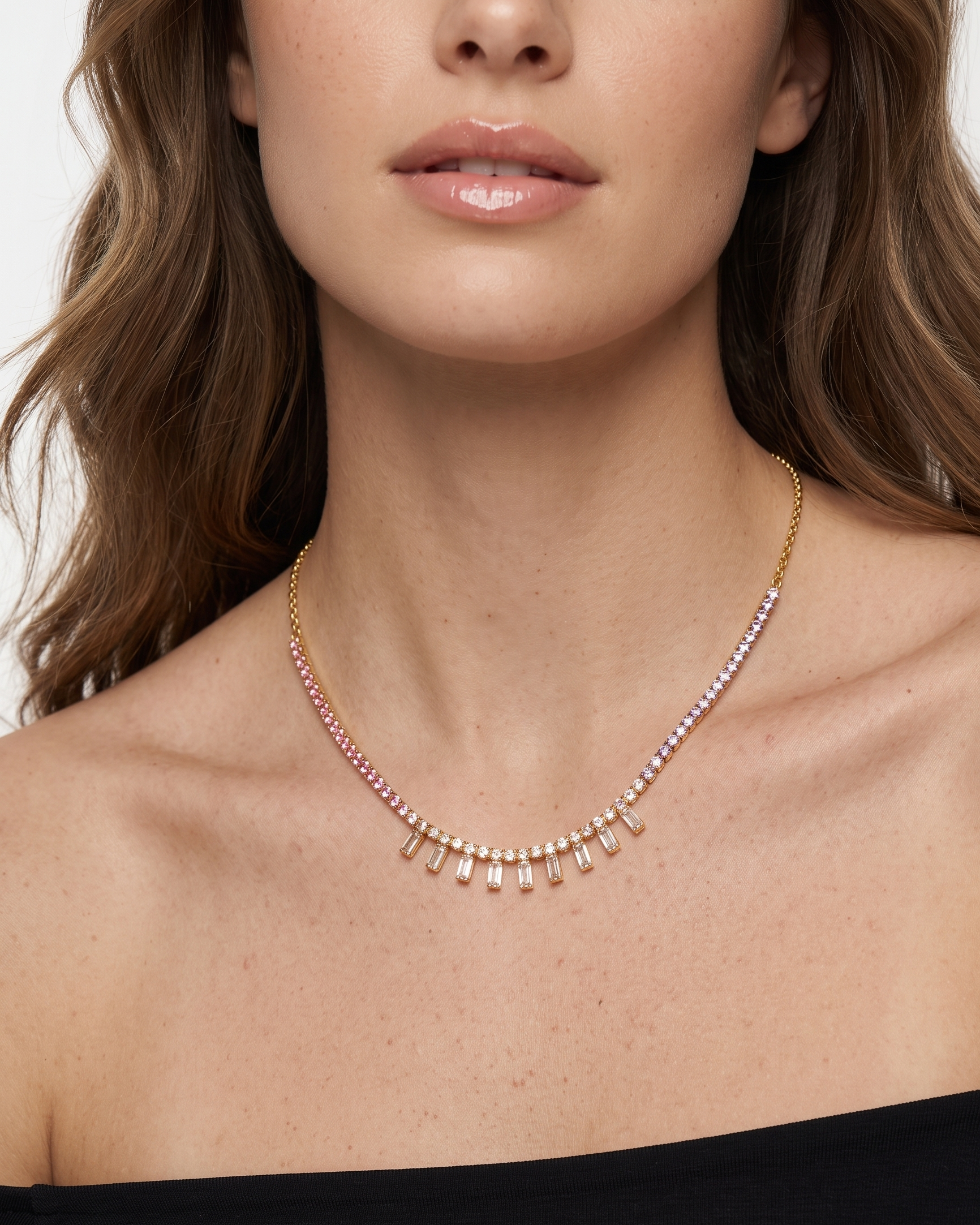 Close-up of a woman wearing a delicate necklace with a plain background