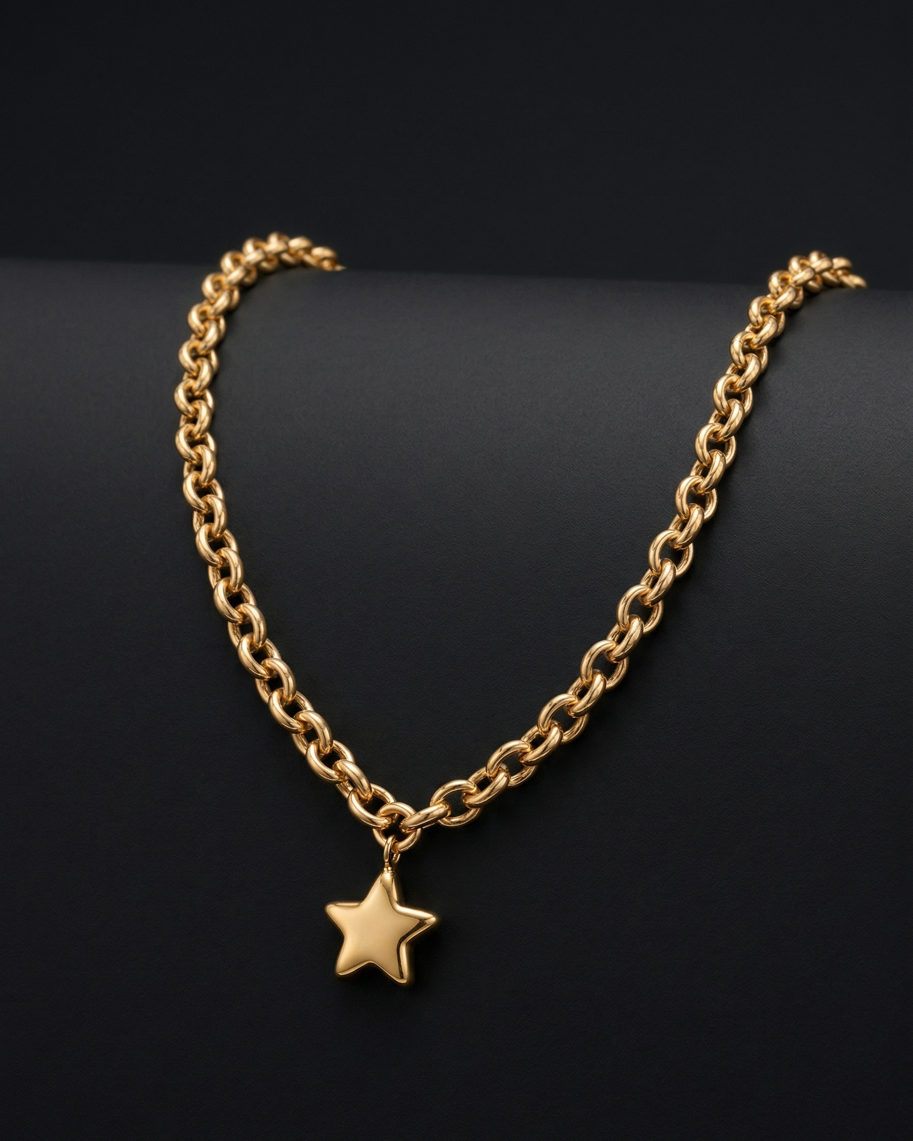 Gold chain necklace with a star pendant on a black background