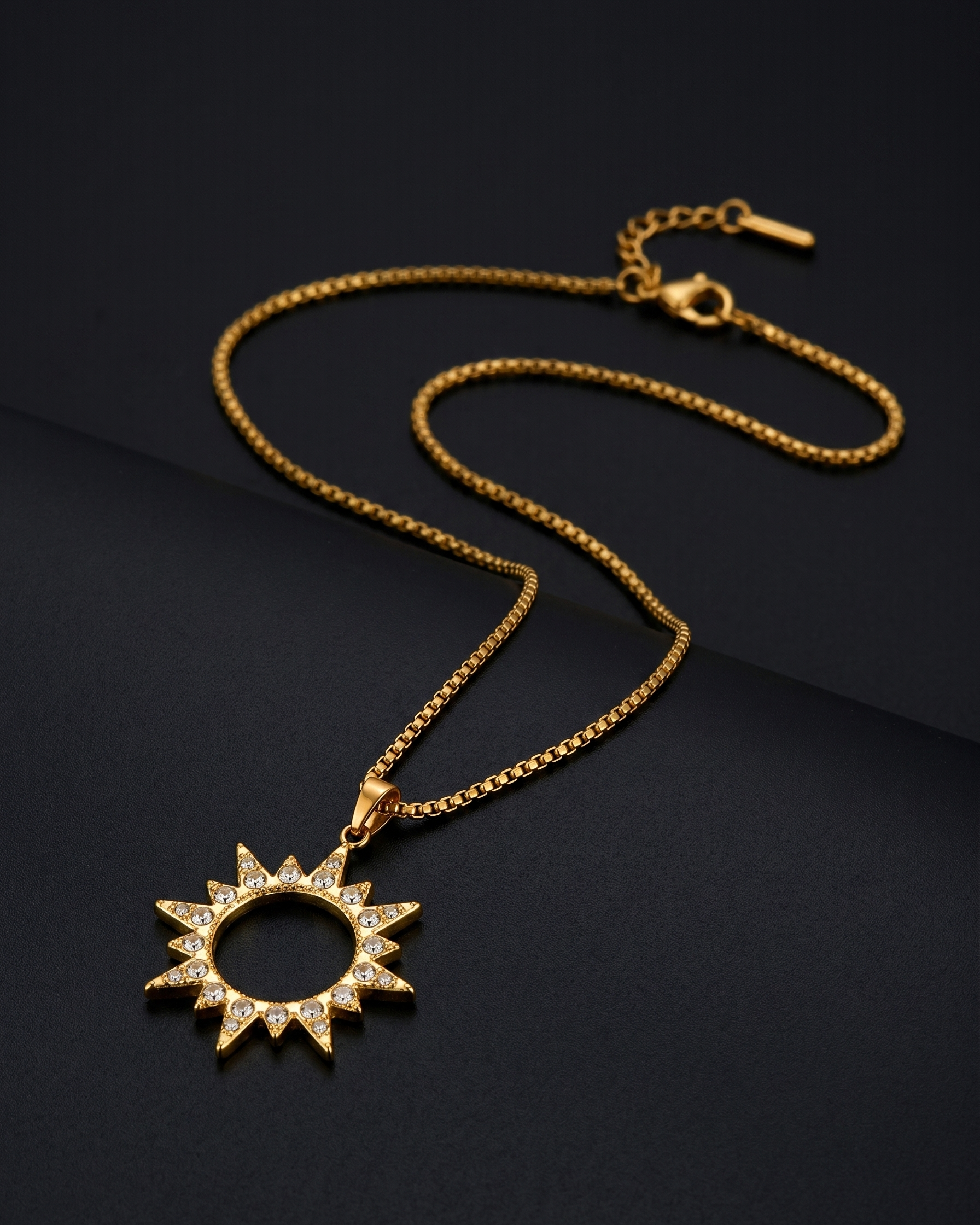 Gold necklace with a sun-shaped pendant on a black background