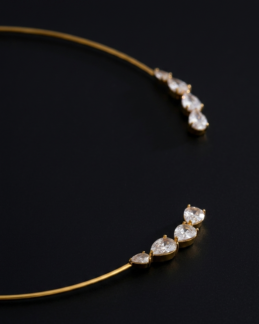 Gold necklace with teardrop-shaped crystals on a black background