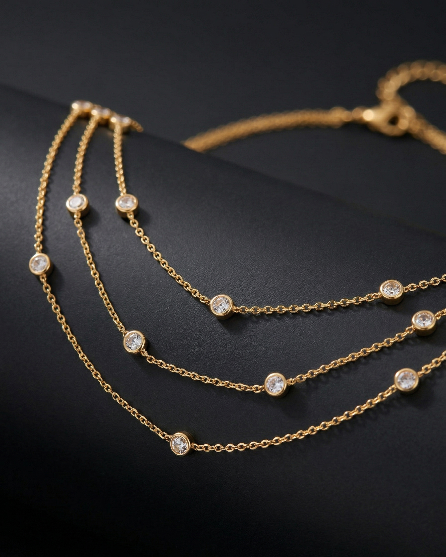 Gold chain necklace with embedded diamonds on a black background