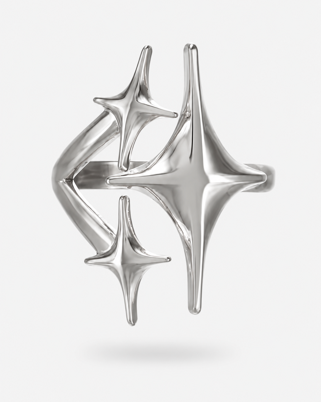 A polished silver ring featuring three interlocking, stylized four-pointed starburst or compass-like shapes, shown on a light gray background.