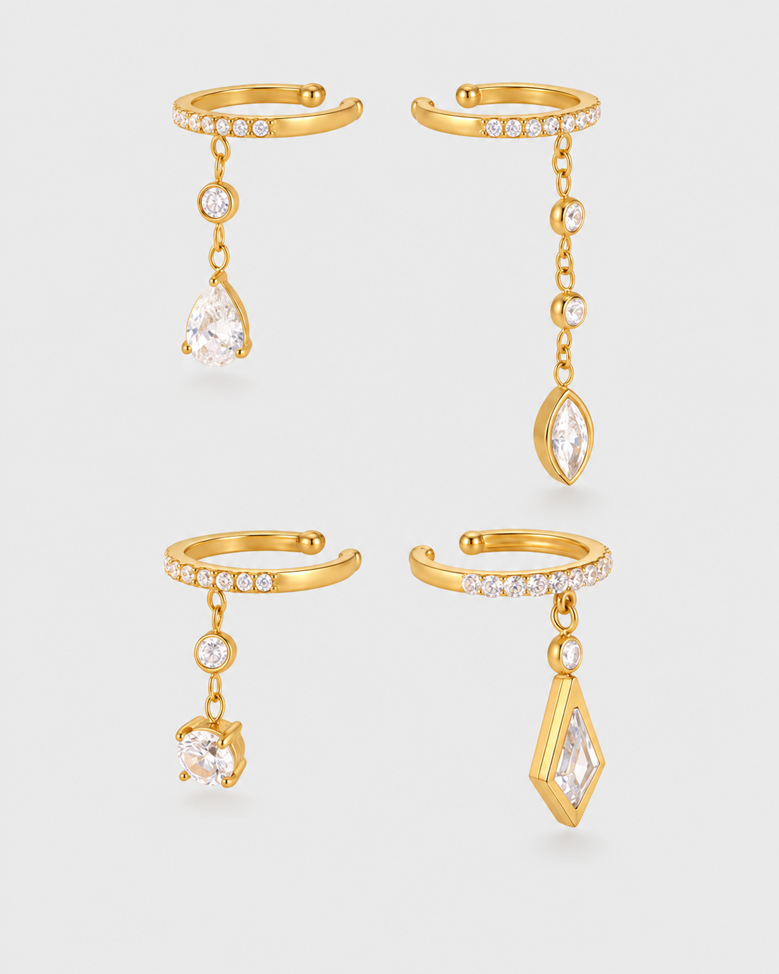 Four gold-toned huggie hoop earrings with dangling crystal charms, arranged in a 2x2 grid on a light gray background.