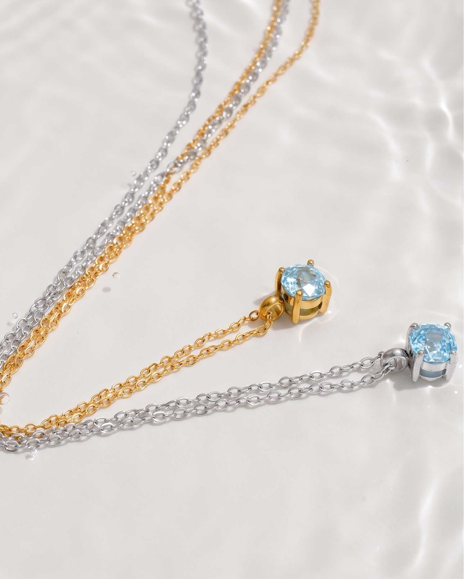 Gold and silver necklace with blue gemstones on a white background