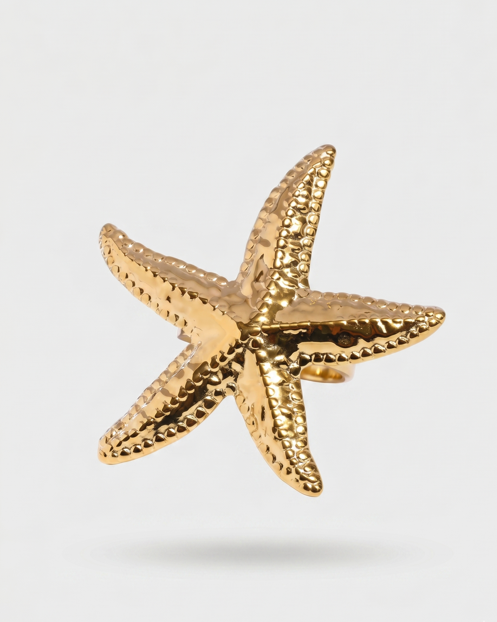 Gold starfish-shaped object on a light gray background