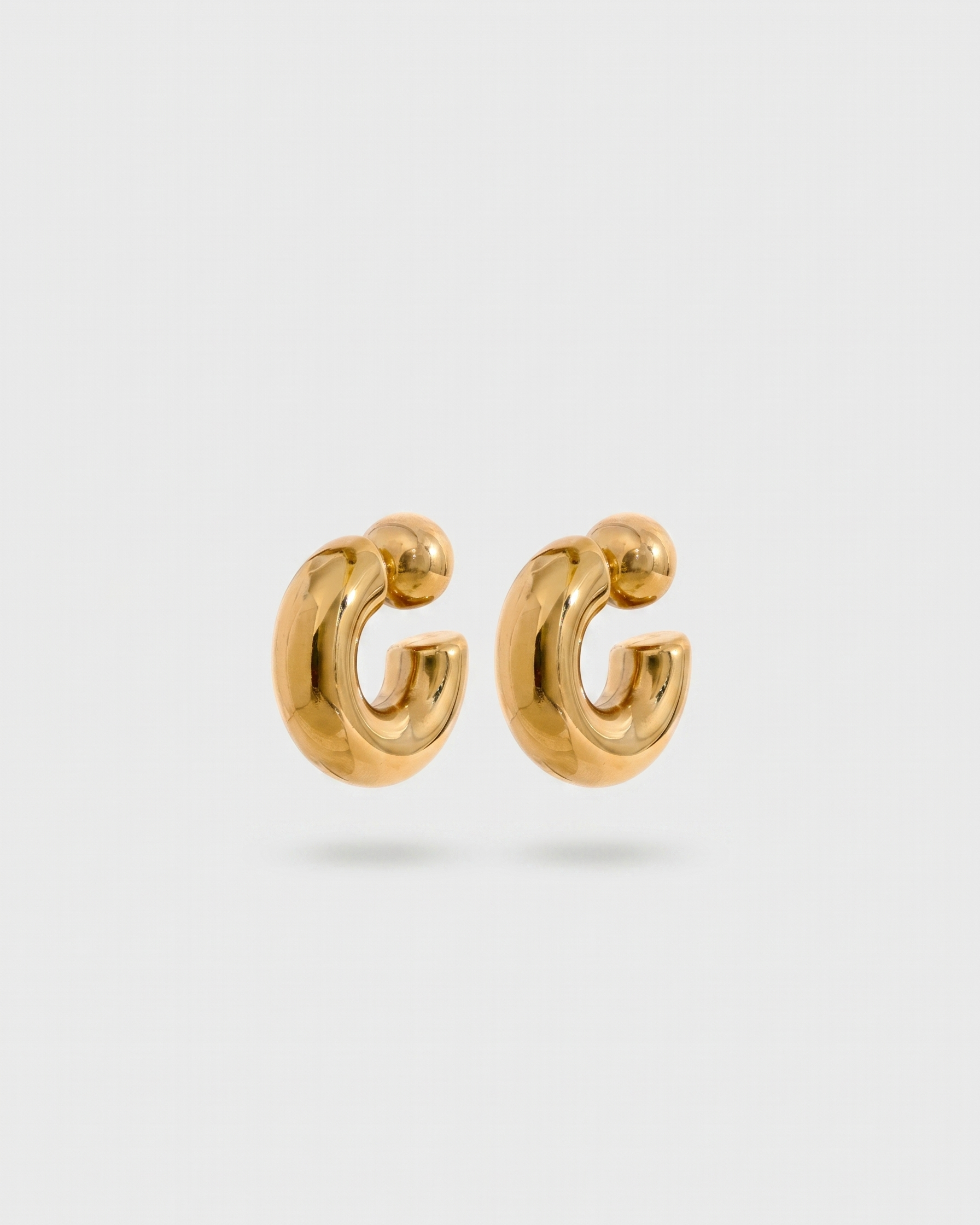 Gold hoop earrings on a light gray background