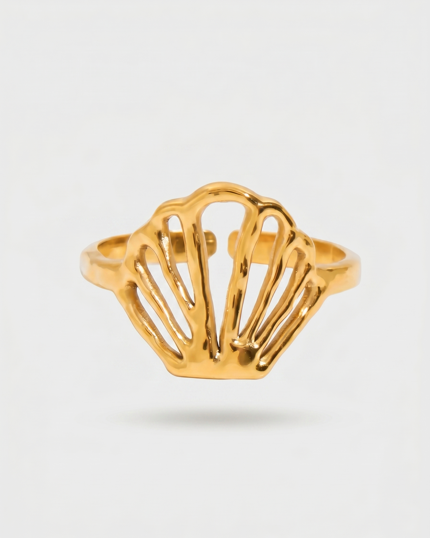 Gold ring with a shell design on a light gray background