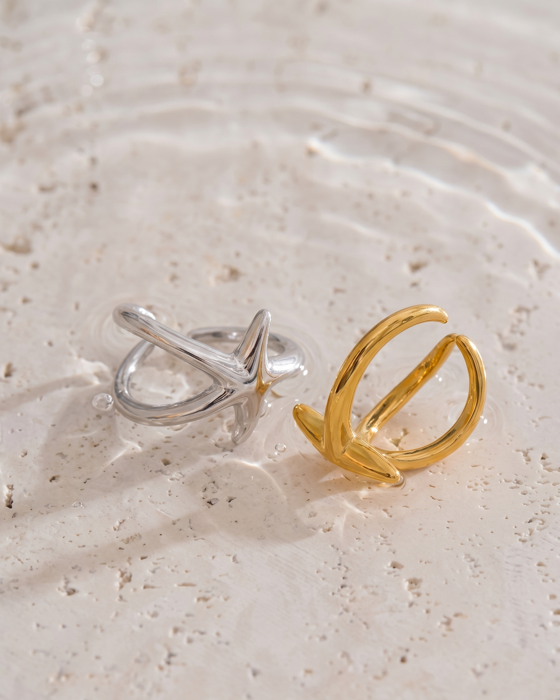 Gold and silver rings on a textured beige surface