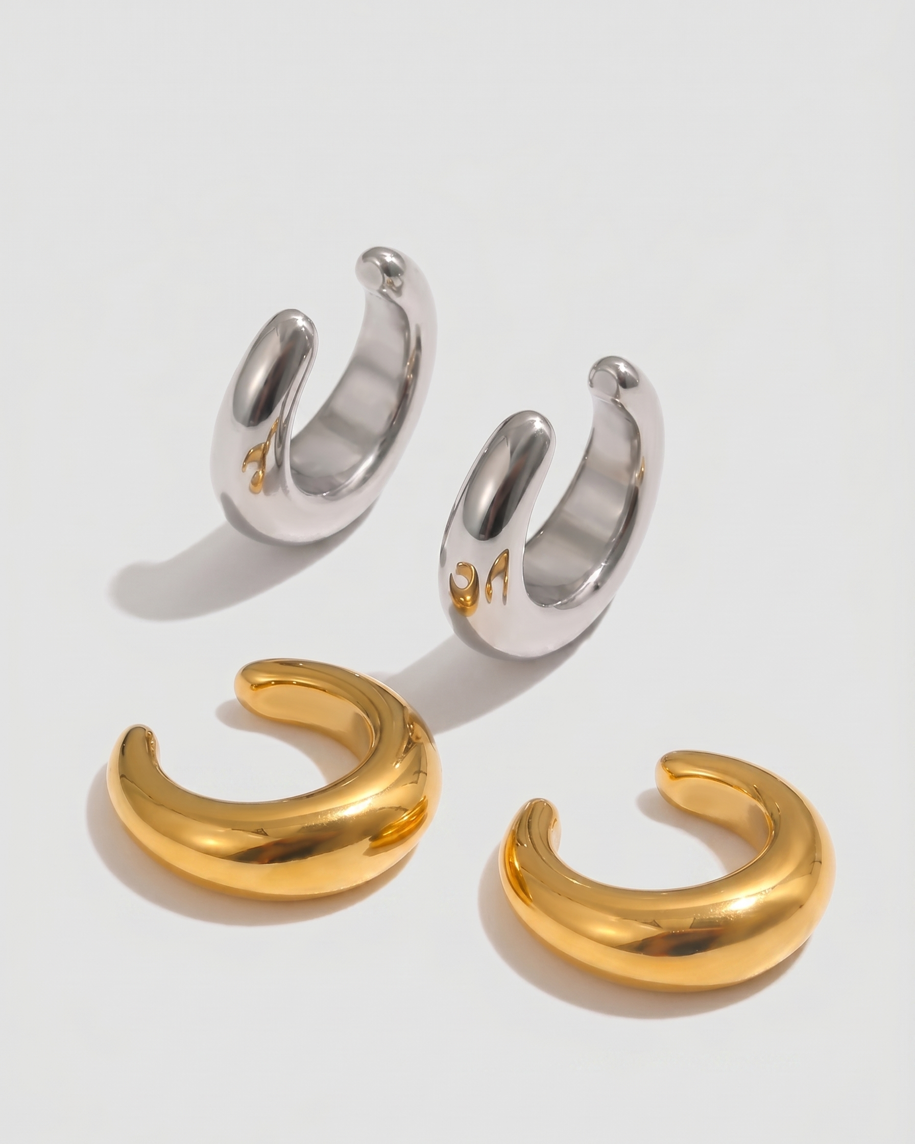 Pair of gold and silver hoop earrings on a white background
