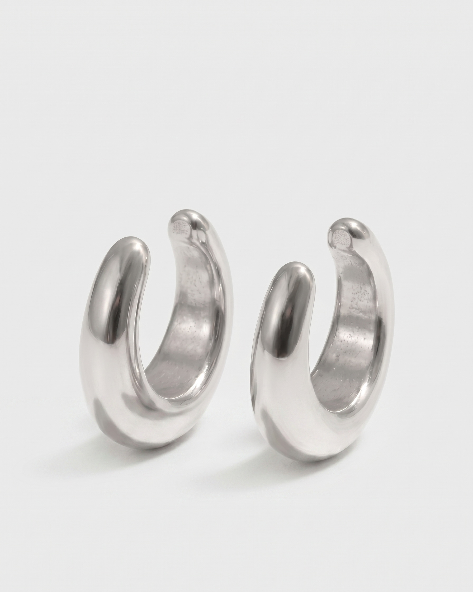 Pair of silver hoop earrings on a white background