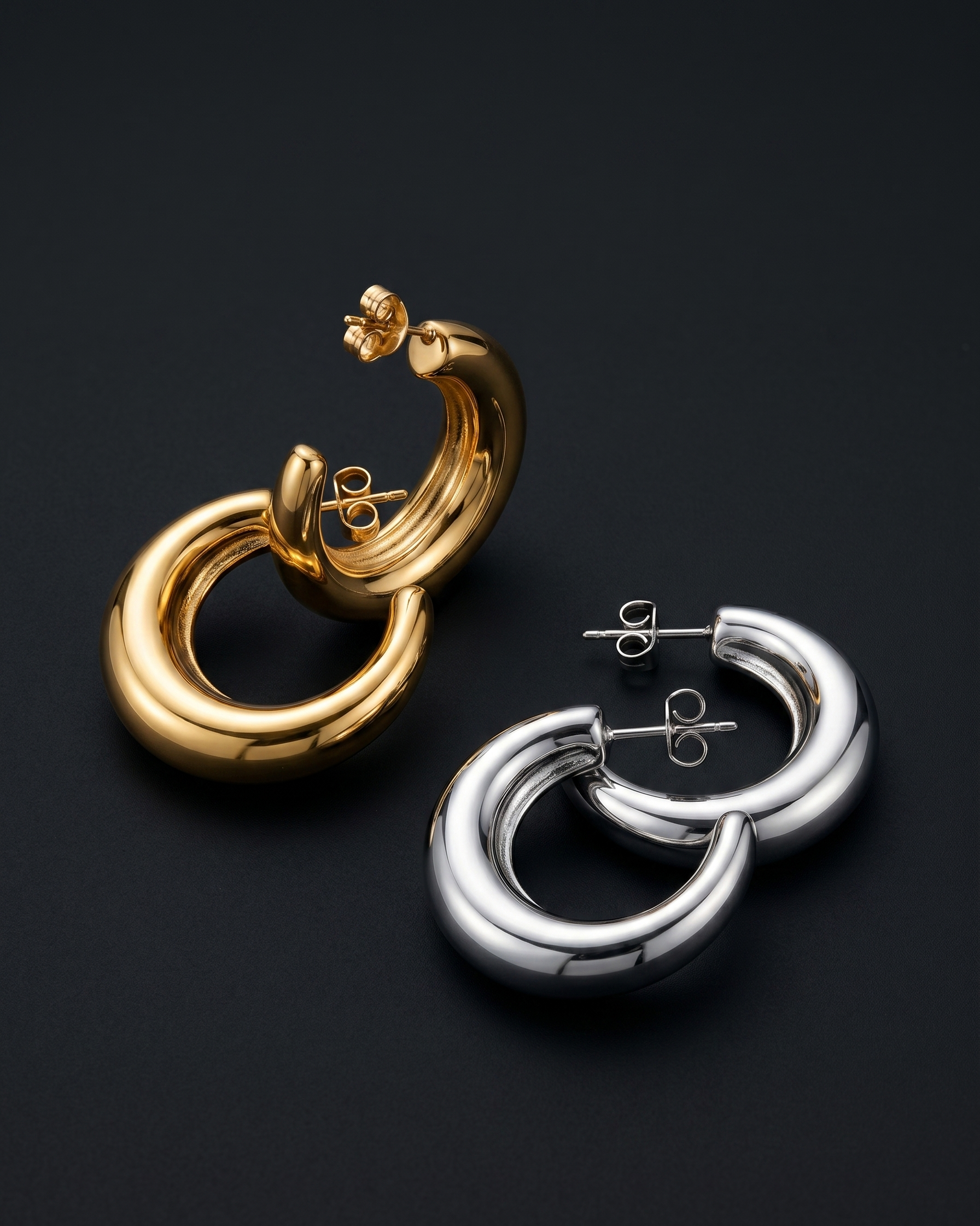 Gold and silver hoop earrings on a dark background