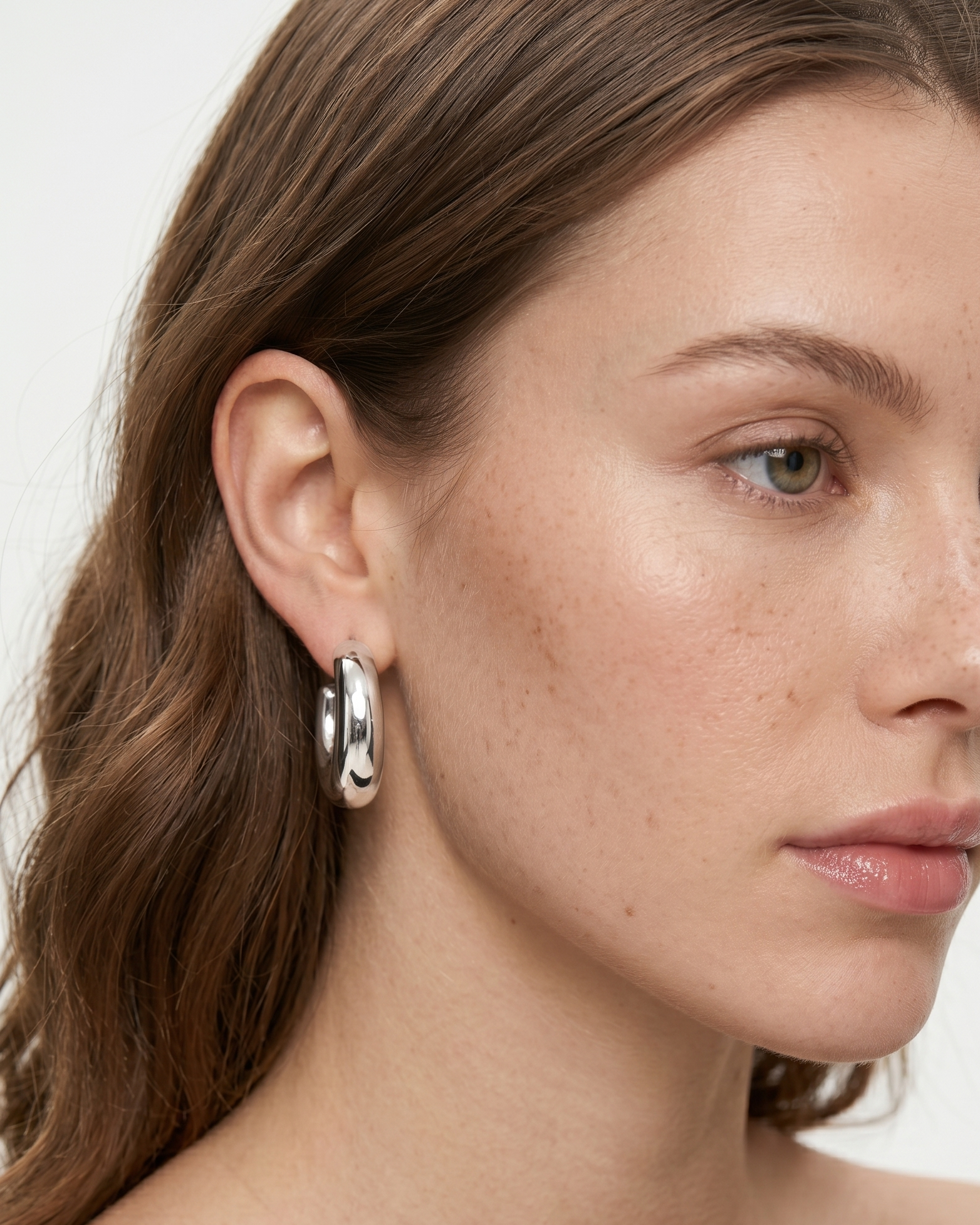 Close-up of a woman wearing a silver earring with a star design.