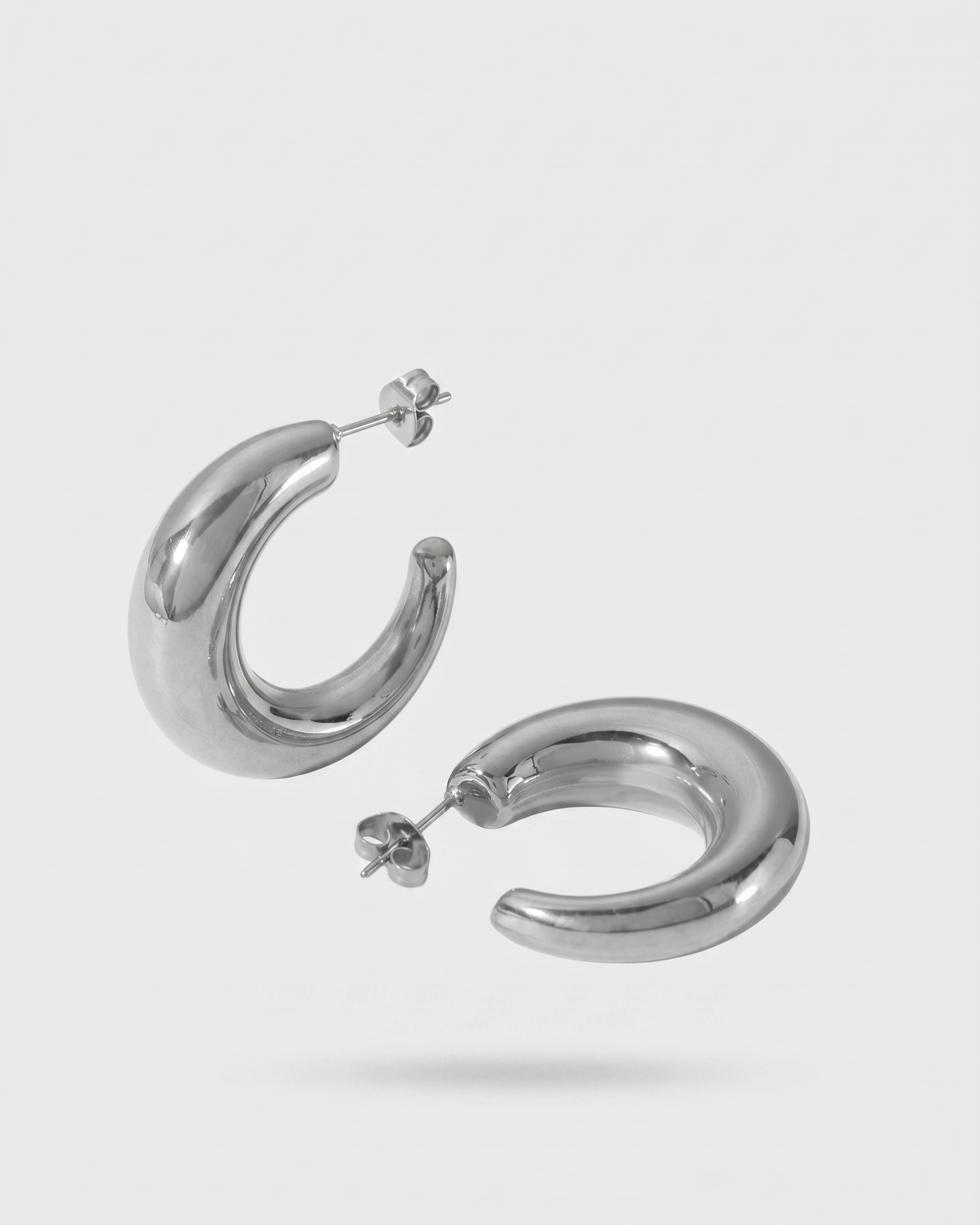 Pair of silver hoop earrings on a light gray background