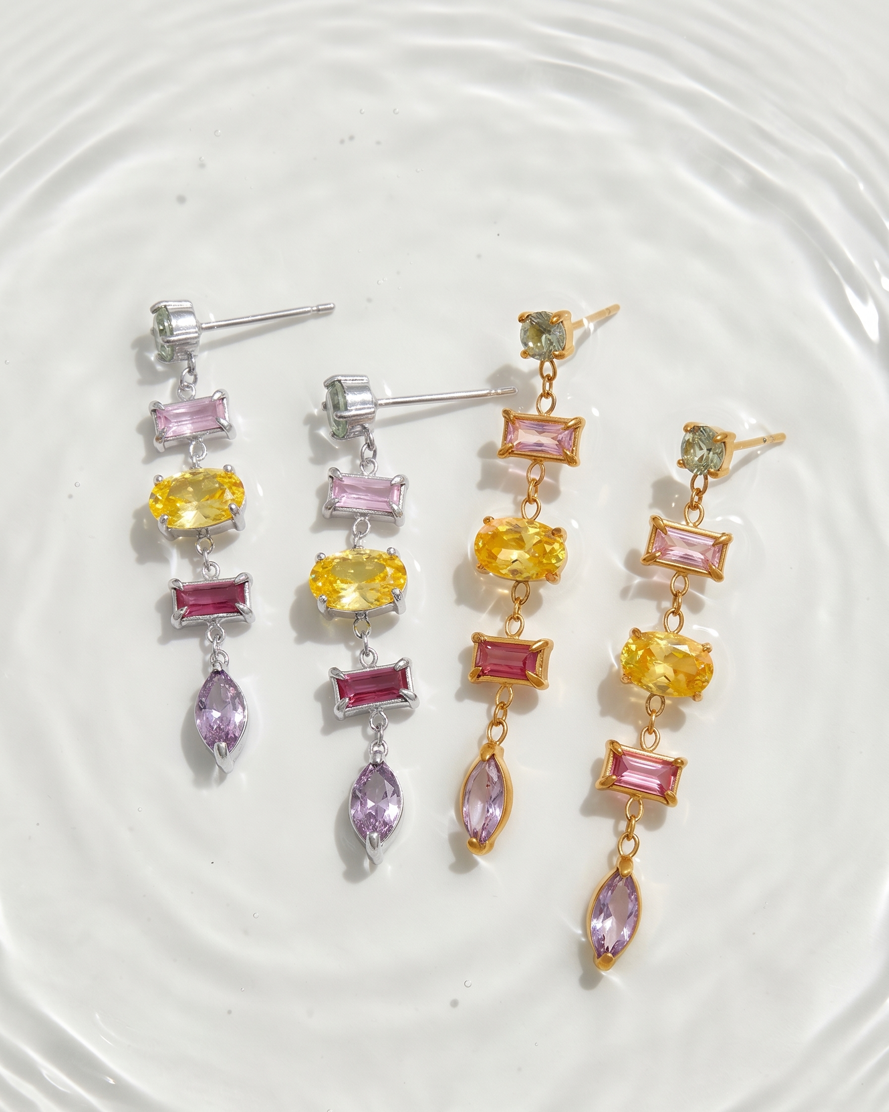 Pair of earrings with multicolored gemstones on a white plate