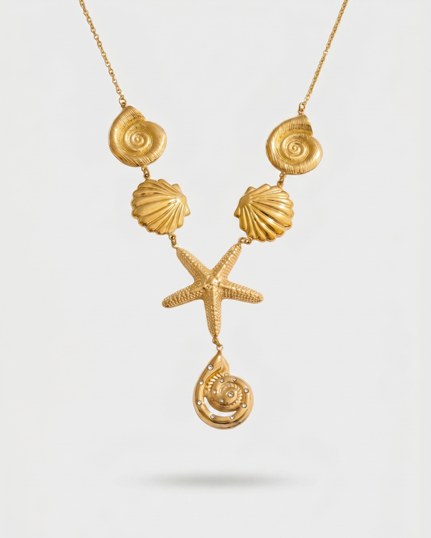 Gold necklace with shell and starfish pendants on a white background