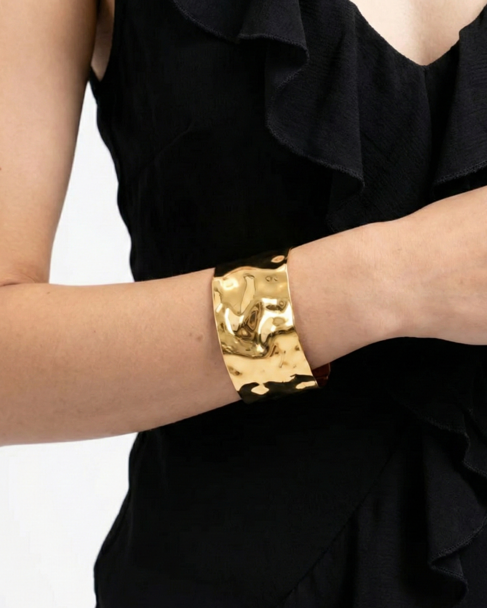 Gold bracelet on a person wearing a black outfit