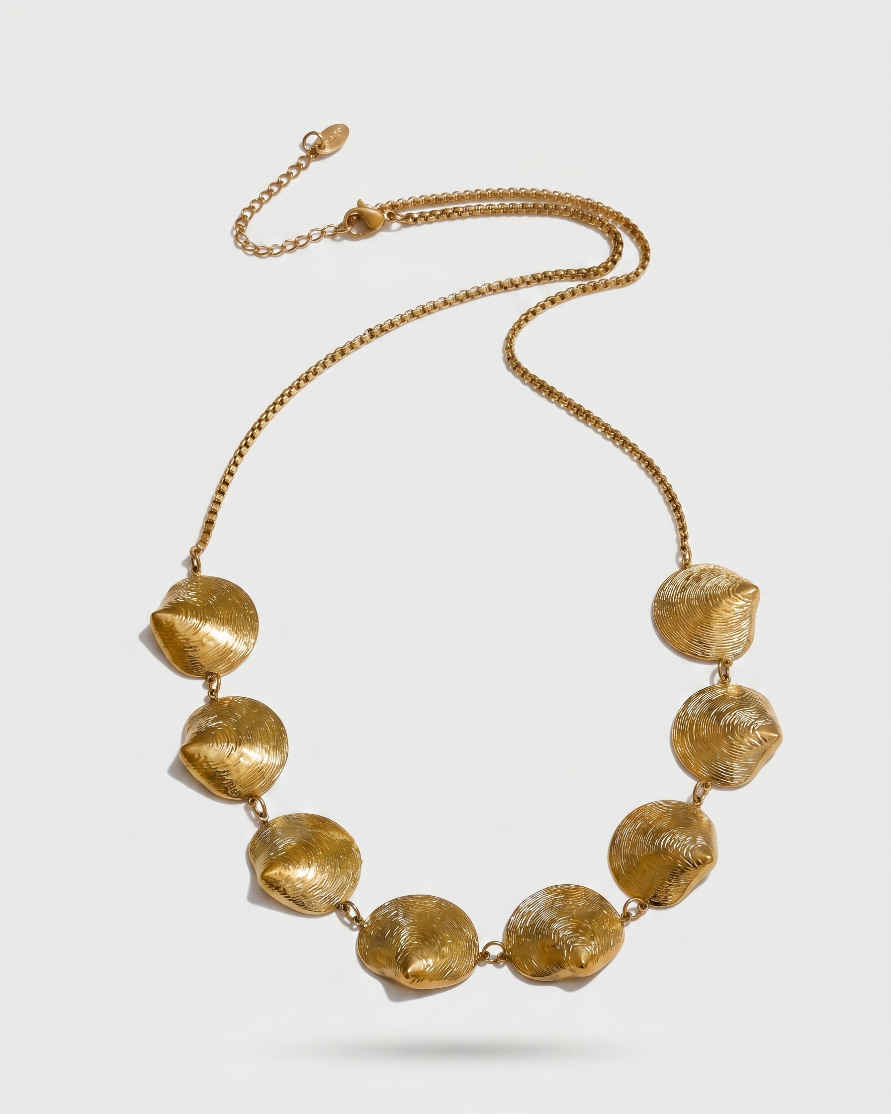Gold necklace with large beads on a white background