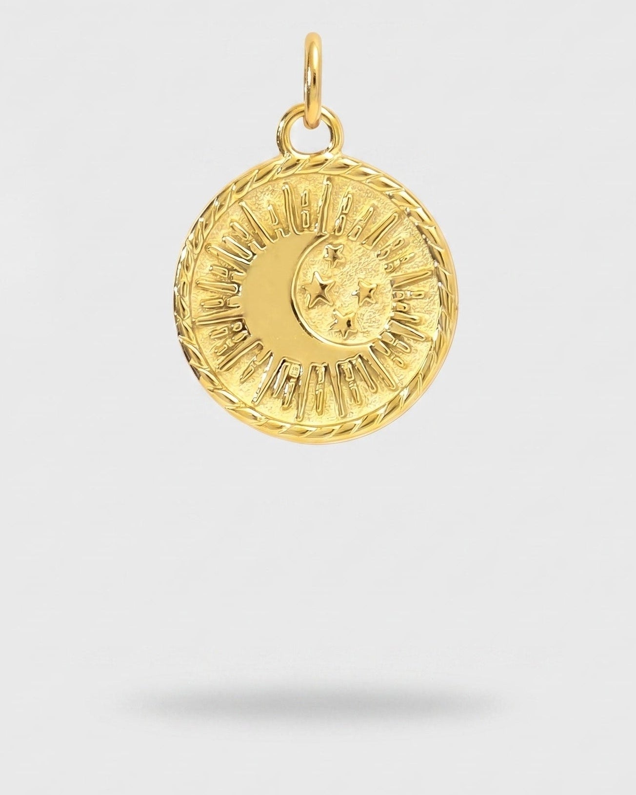 A gold circular pendant featuring a sun and crescent moon design, suspended against a light gray background with a soft shadow below.