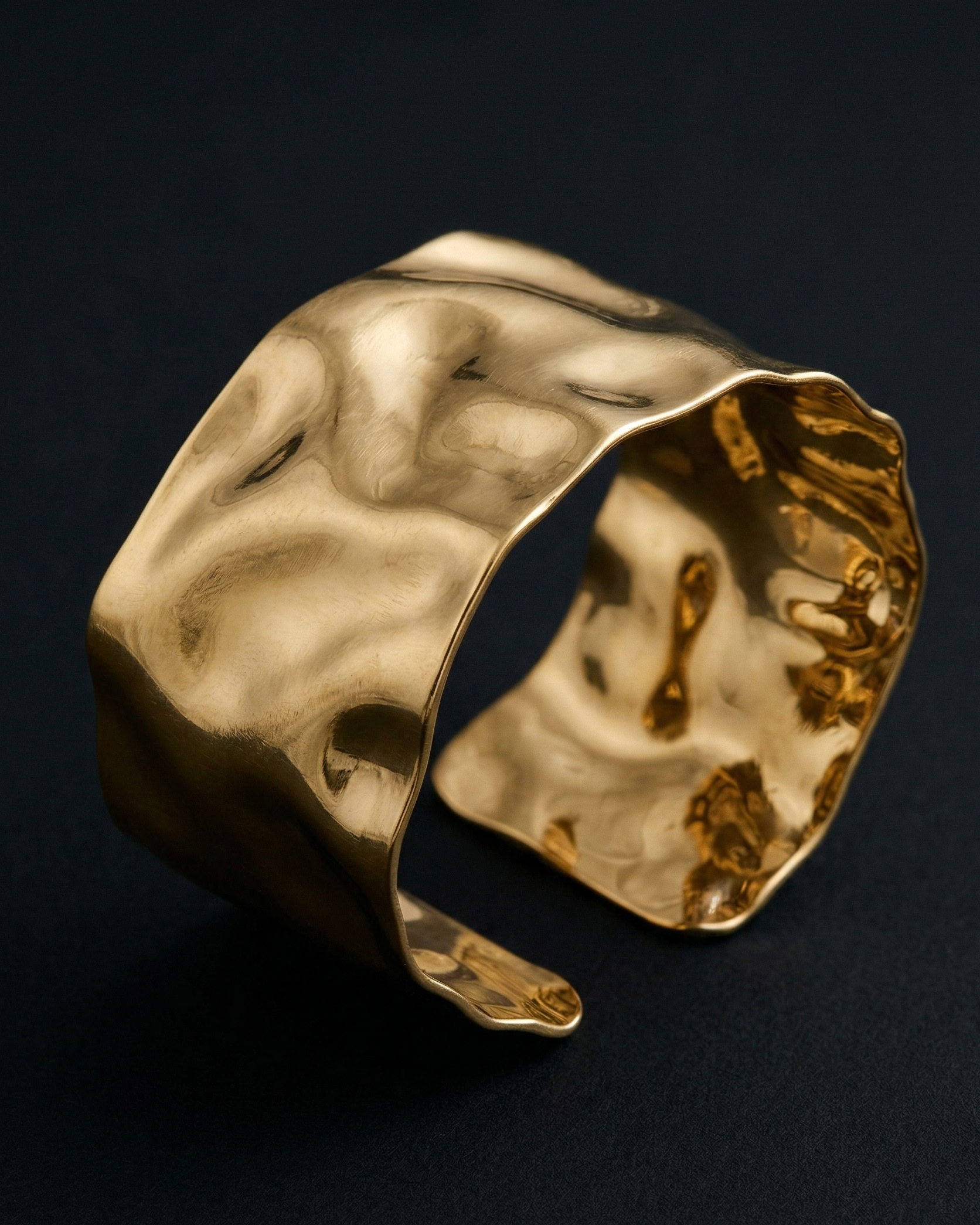 Gold ring with a textured surface on a dark background