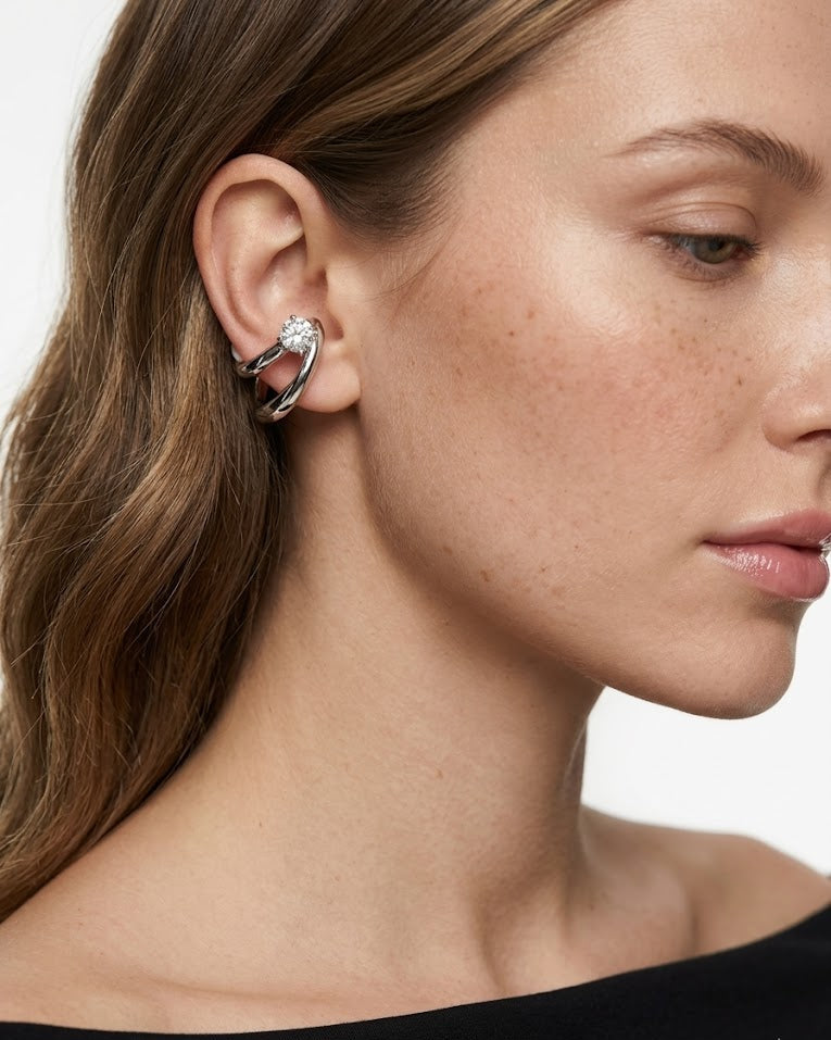 Close-up of a woman wearing a silver hoop earring with a blurred background