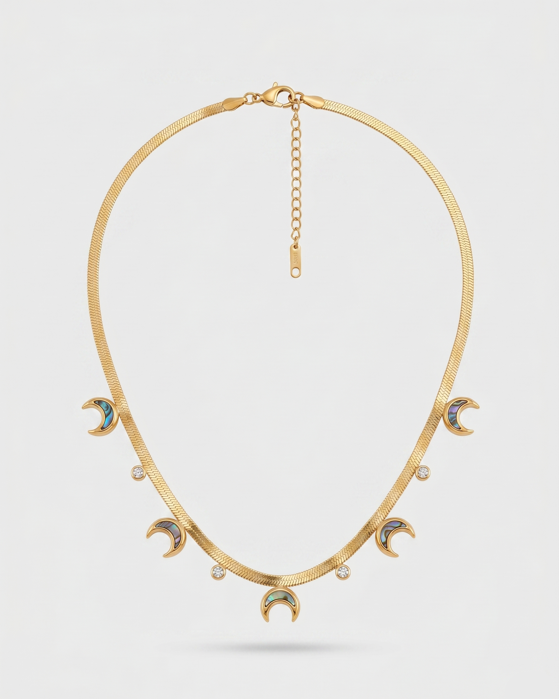 Gold necklace with moon-shaped pendants on a light gray background
